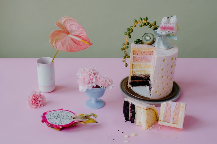Whimsical cake styling with pink anthurium, polka dot cake, dragonfruit and carnations