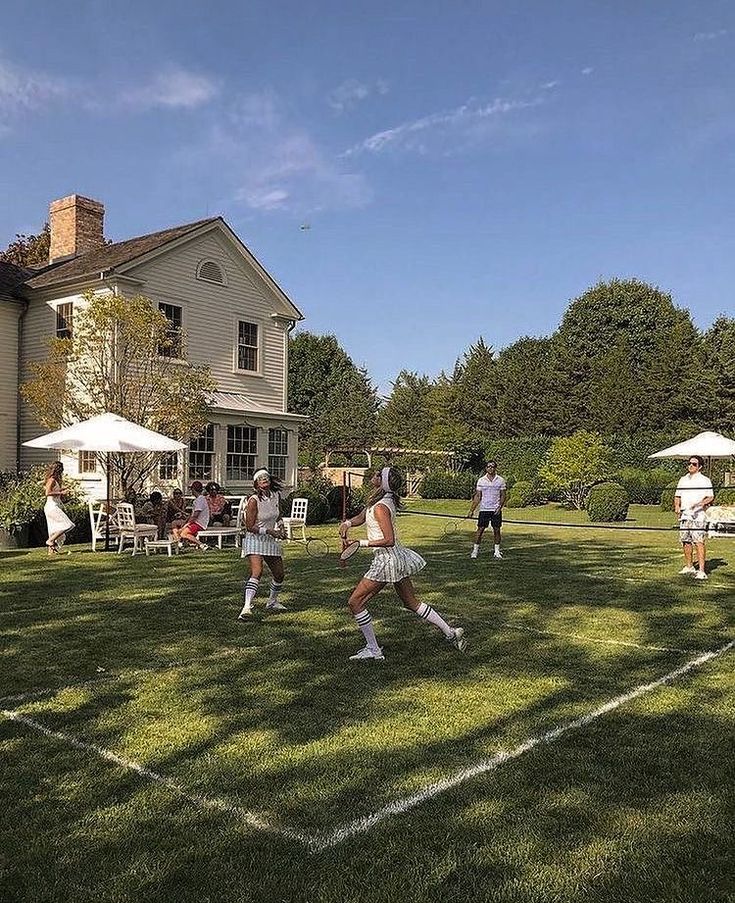 Tennis match being played on a luxurious estate's grass court