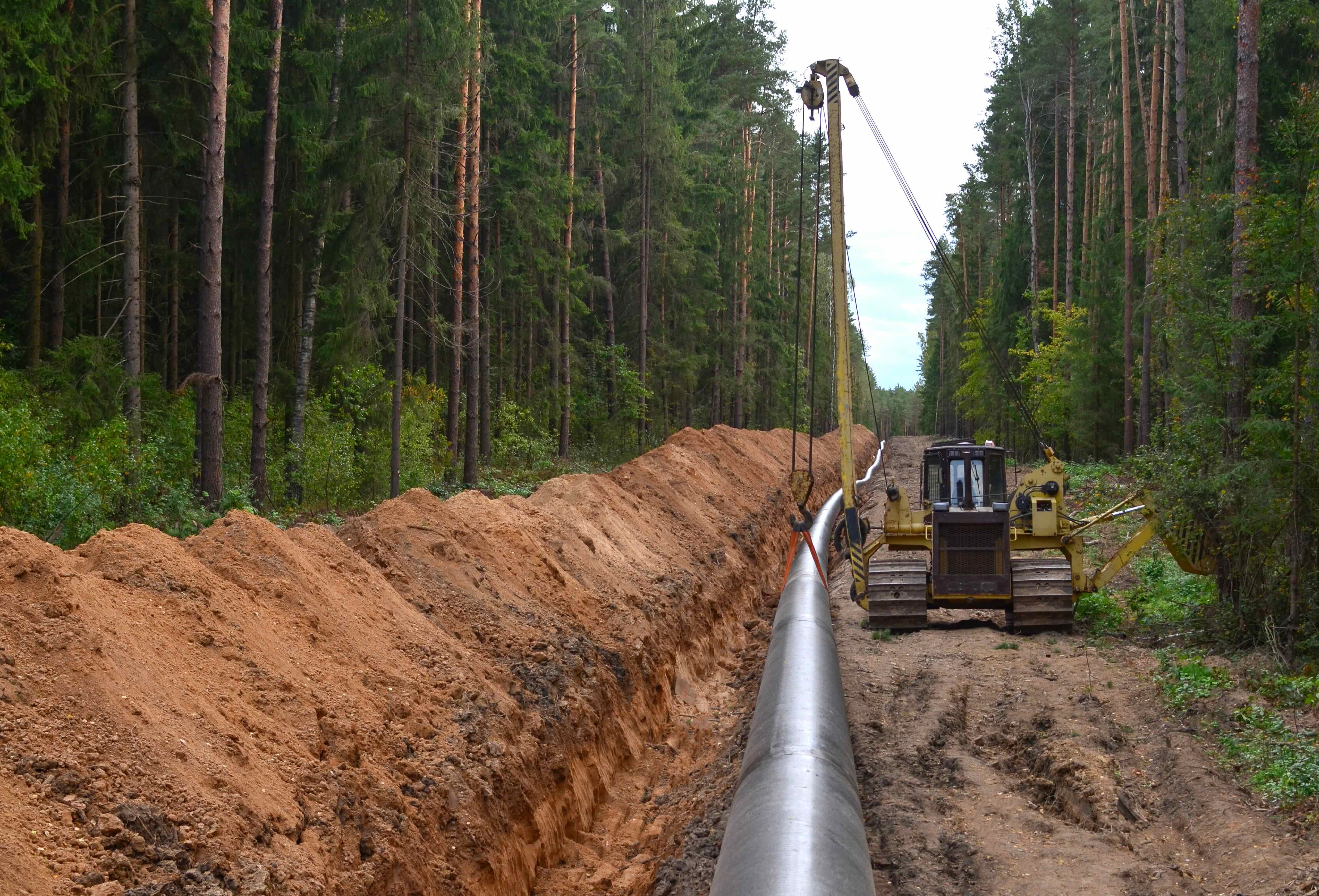 Traditional pipeline installation with heavy excavation through forest