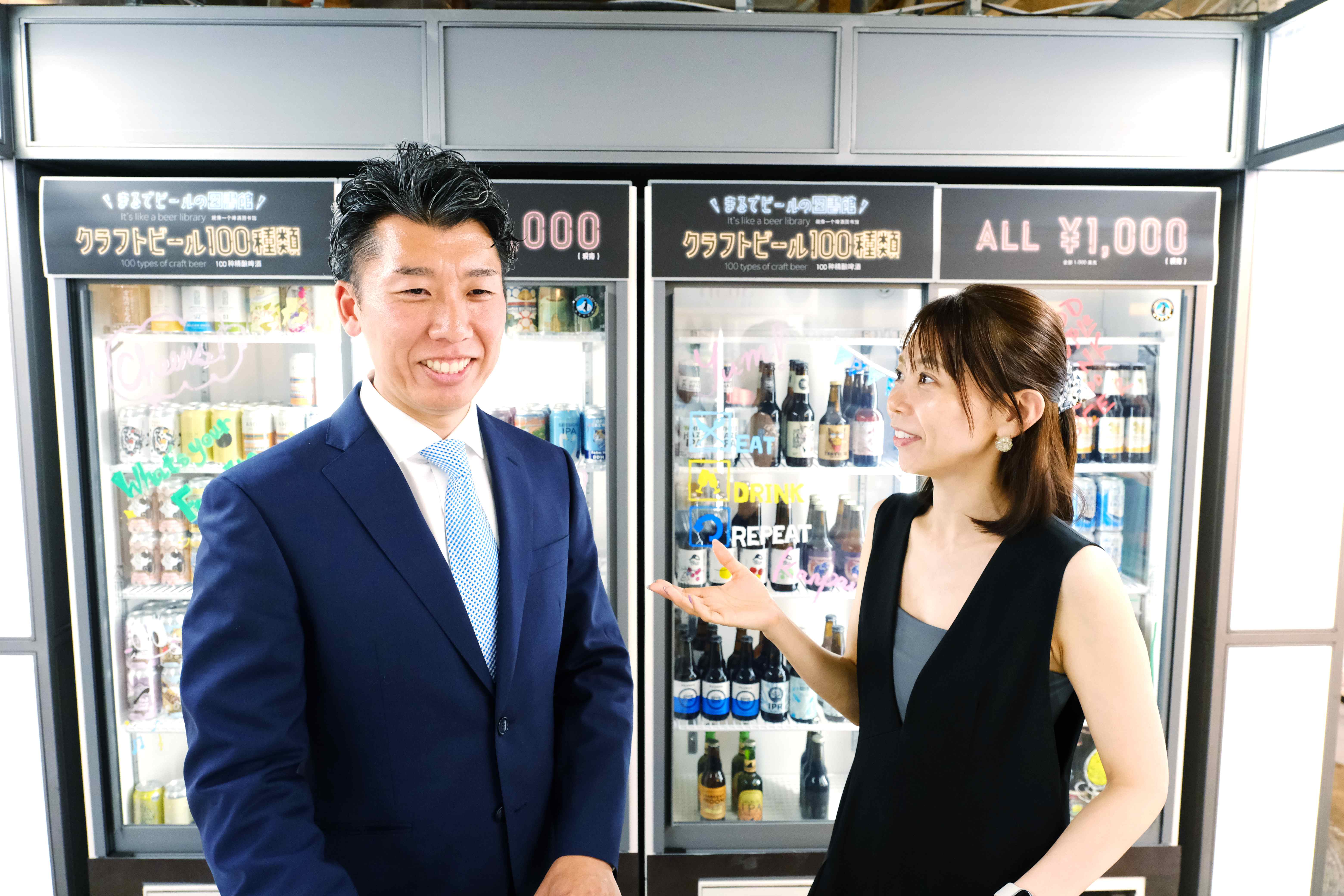 クラフトビール冷蔵庫の前に立つ小嶋さんと若林さん