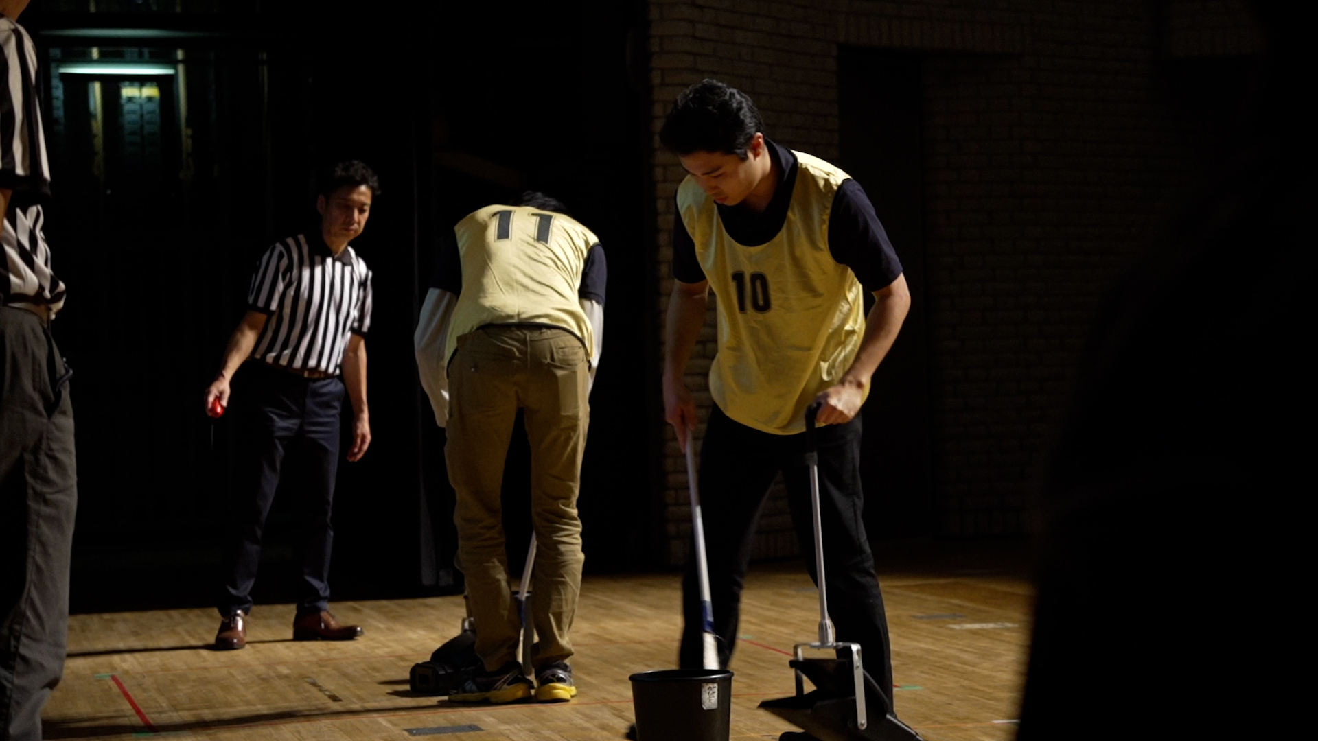 掃き掃除の競技中 - 審判と選手