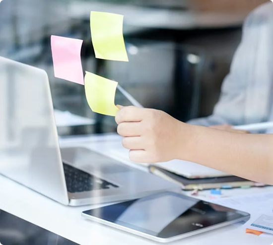 Hand placing colorful sticky notes on glass surface