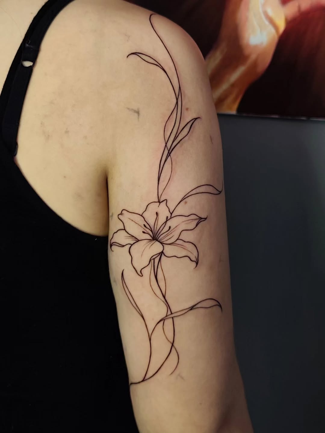 Tatuagem fine line de lírio