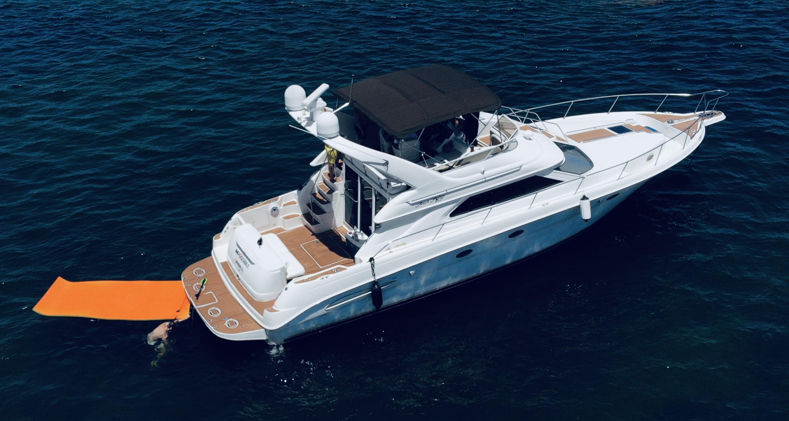 Sea Ray Flybridge yacht aerial view anchored on open water with wide horizon