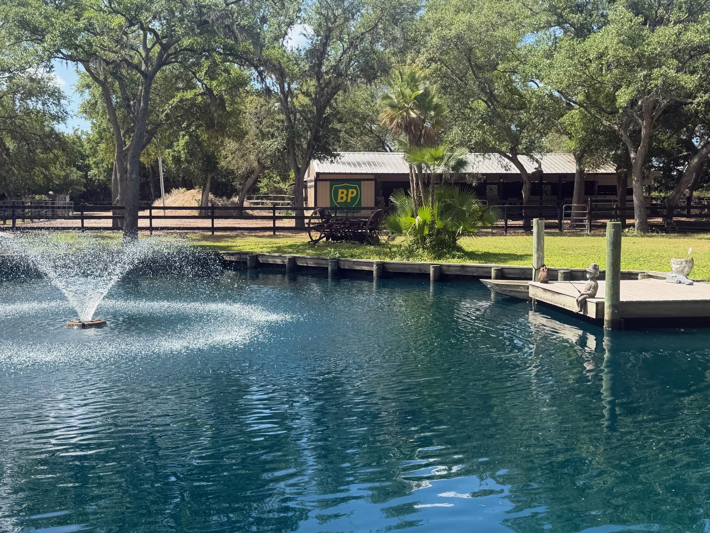 Wood seawall and dock along private pond with fountain