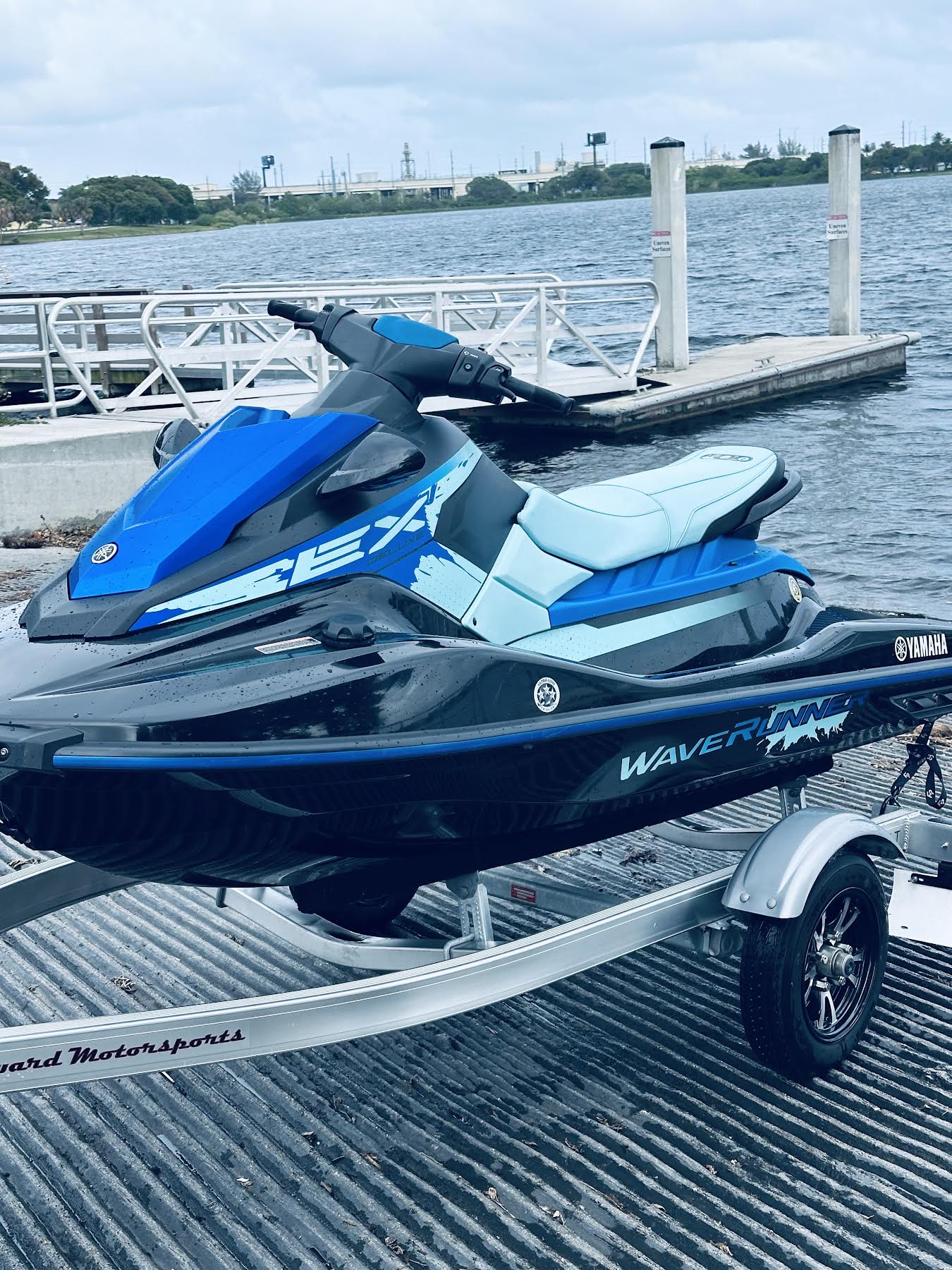 Blue and black Yamaha WaveRunner EX on trailer at marina dock