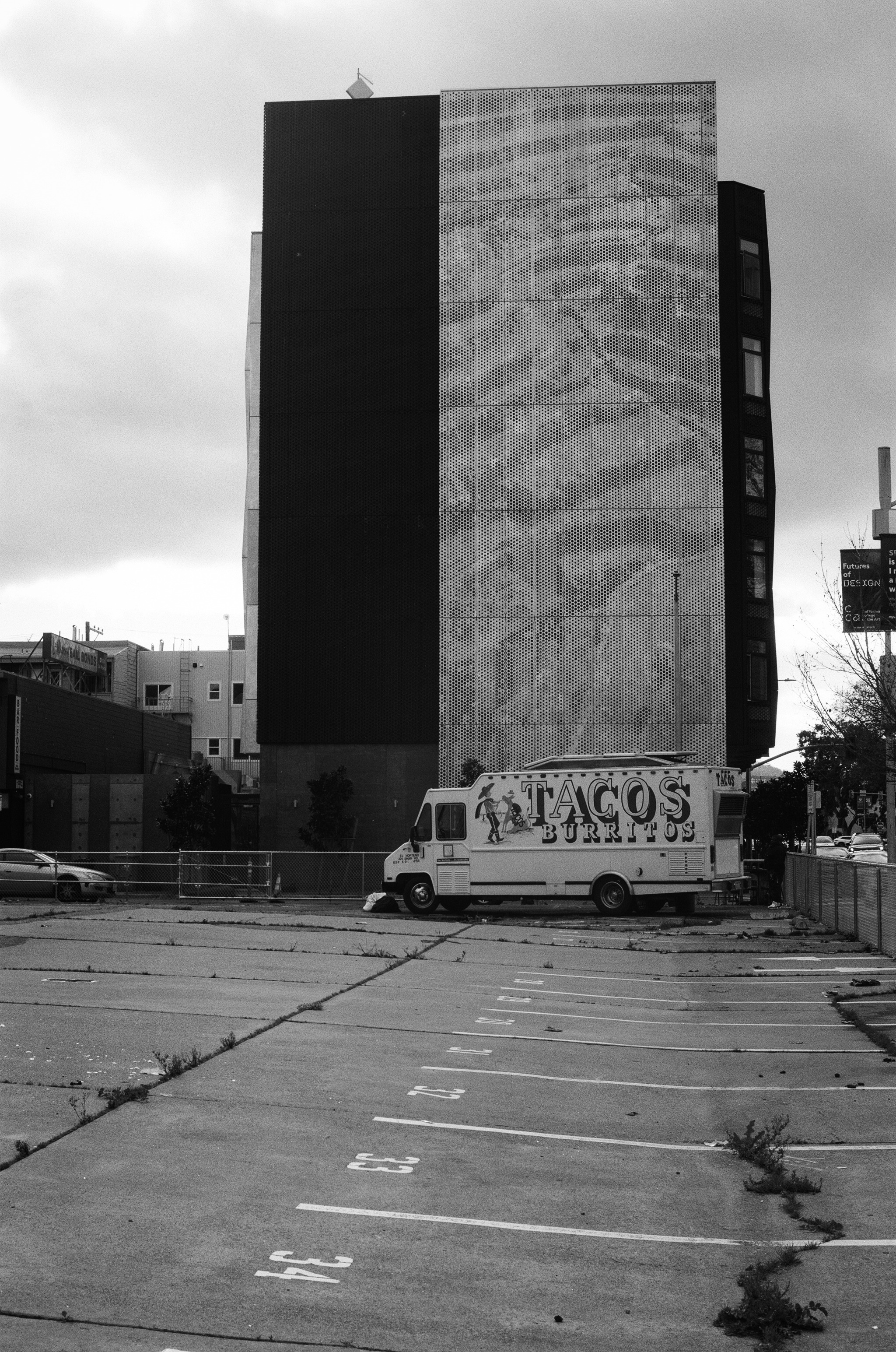 Parking payment kiosk machine on sidewalk with car passing in background
