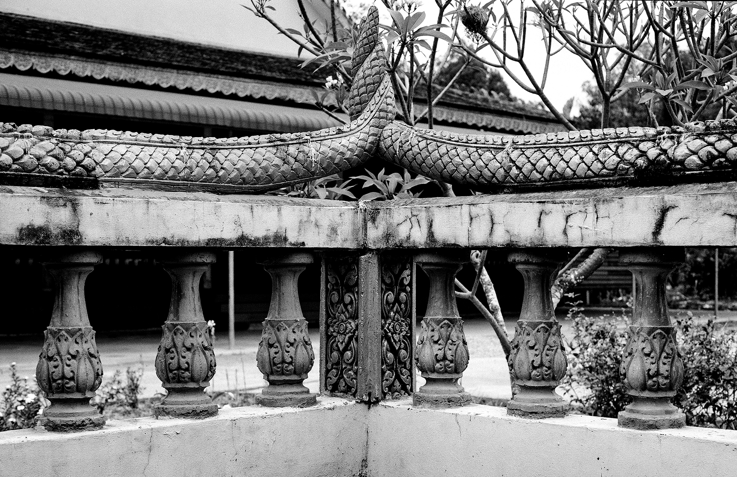 Ornate temple columns supporting curved roof with carved capitals and decorative elements