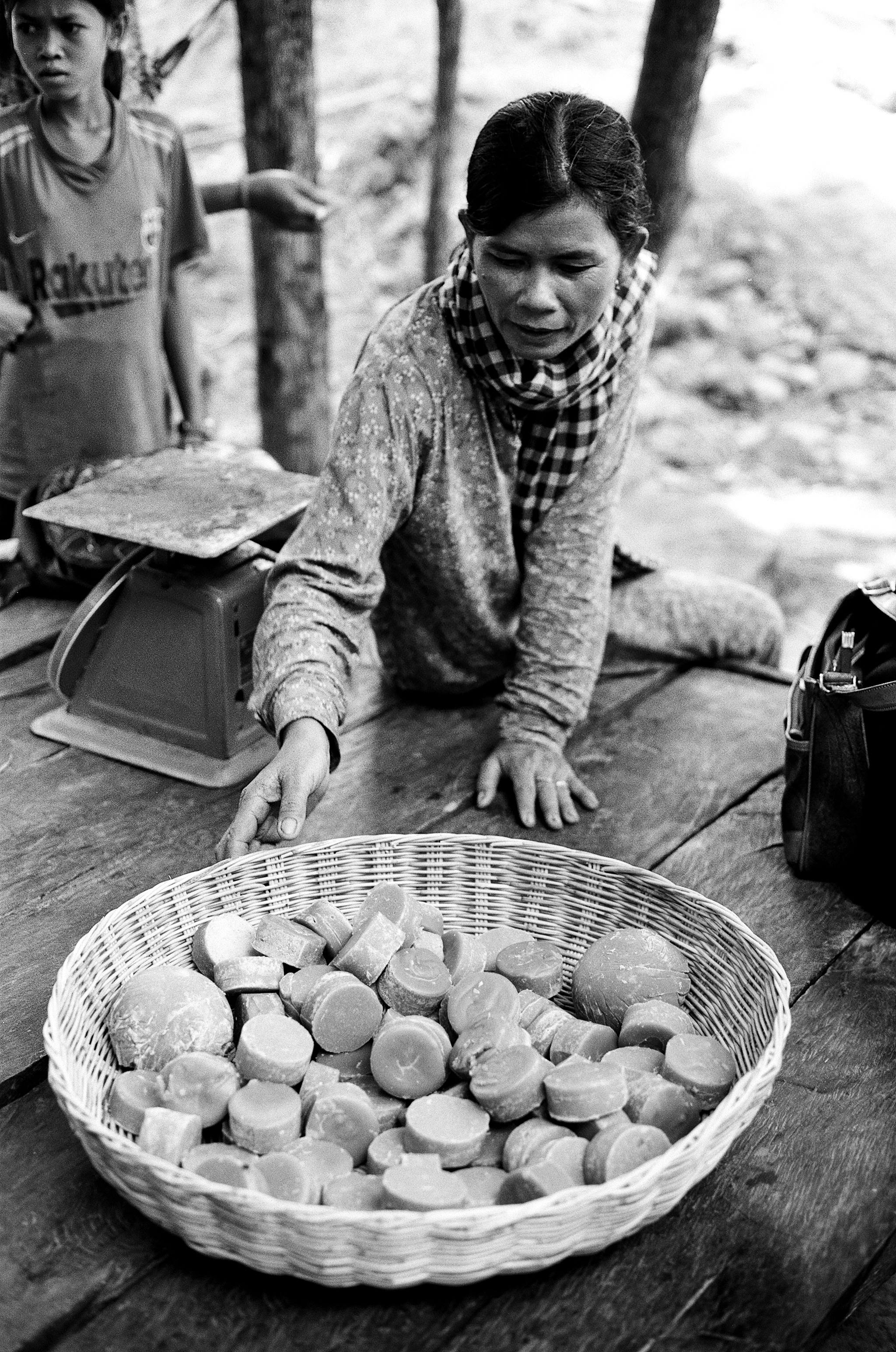 Woman preparing food with basket of vegetables and traditional cooking methods