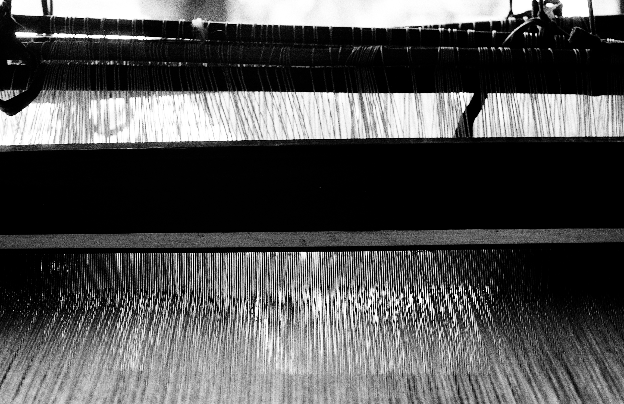 Wide perspective of traditional textile loom with white thread patterns