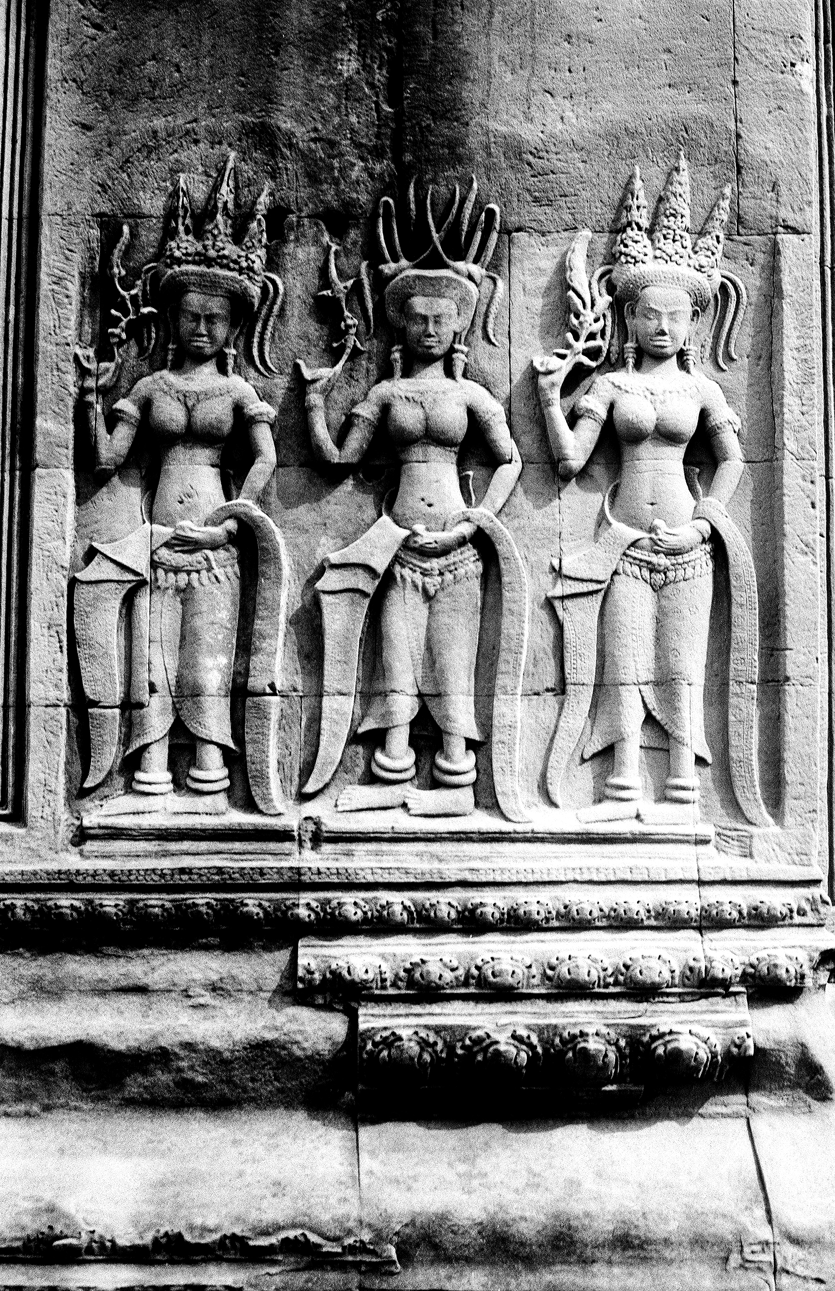 Three ornate temple guardian statues with tall pointed crowns and sacred mudras