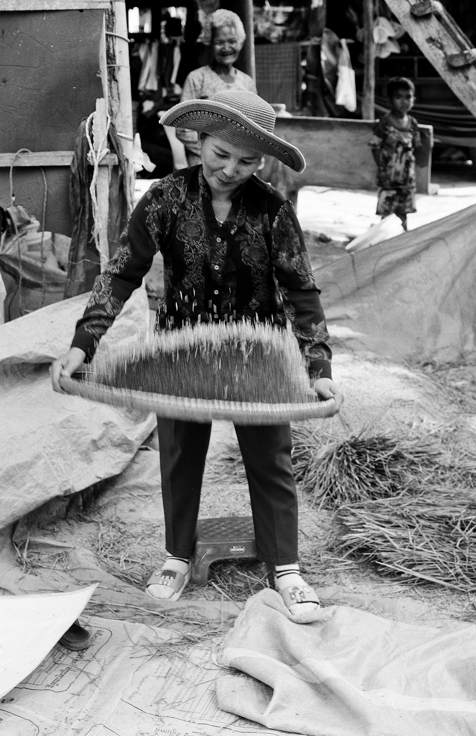 Elderly woman in hat holding woven basket with traditional rope weaving