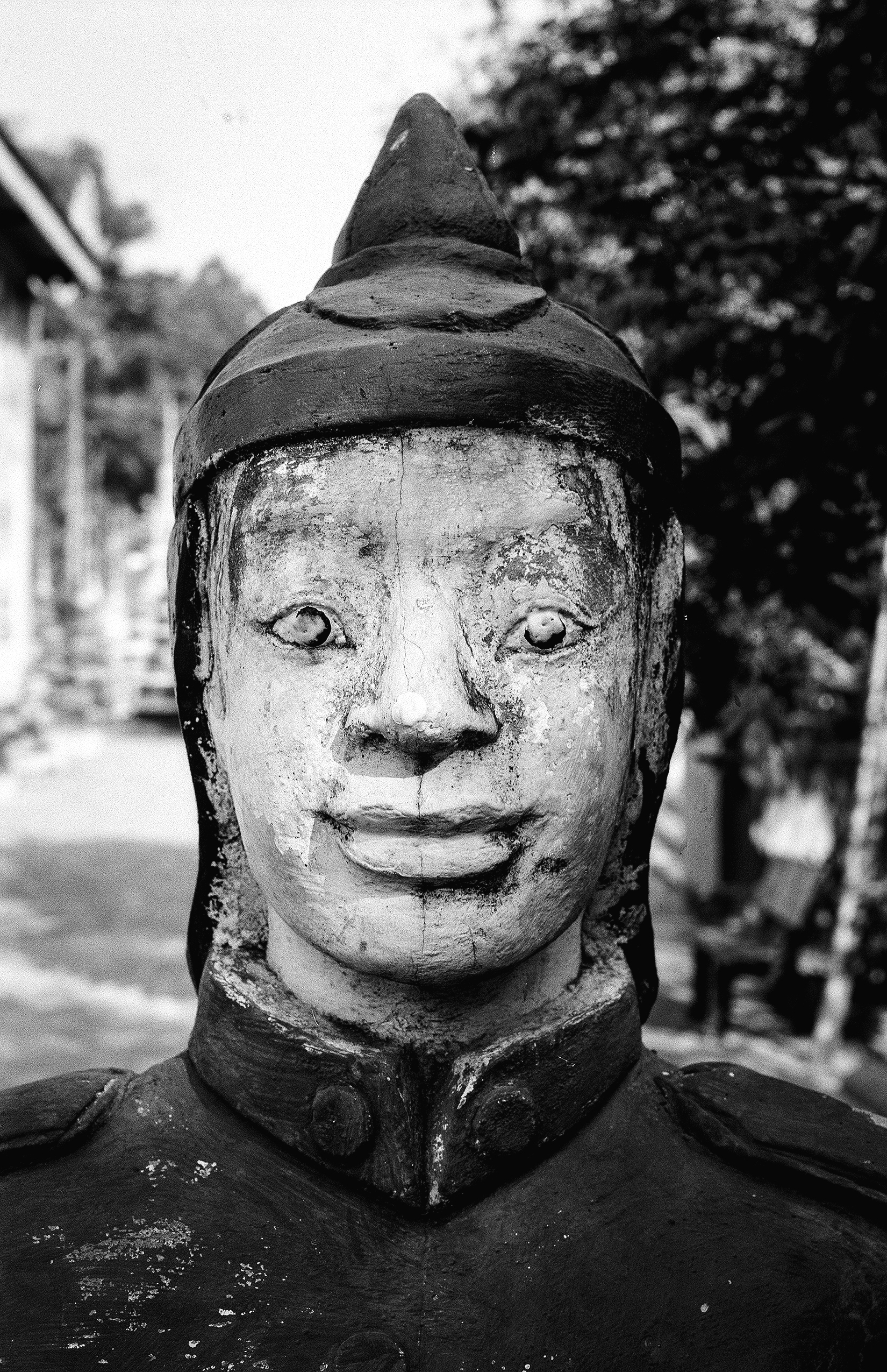 Weathered stone head sculpture with serene expression and ornate crown