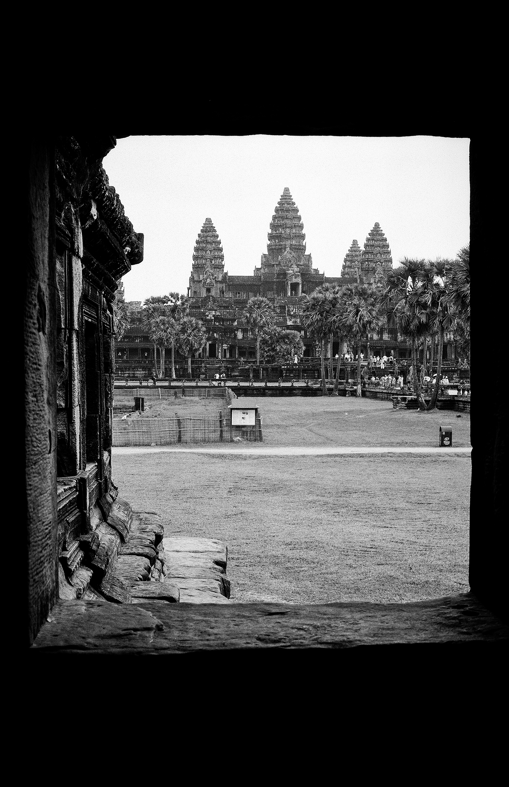 Framed view of Angkor Wat temple complex through stone gateway entrance portal