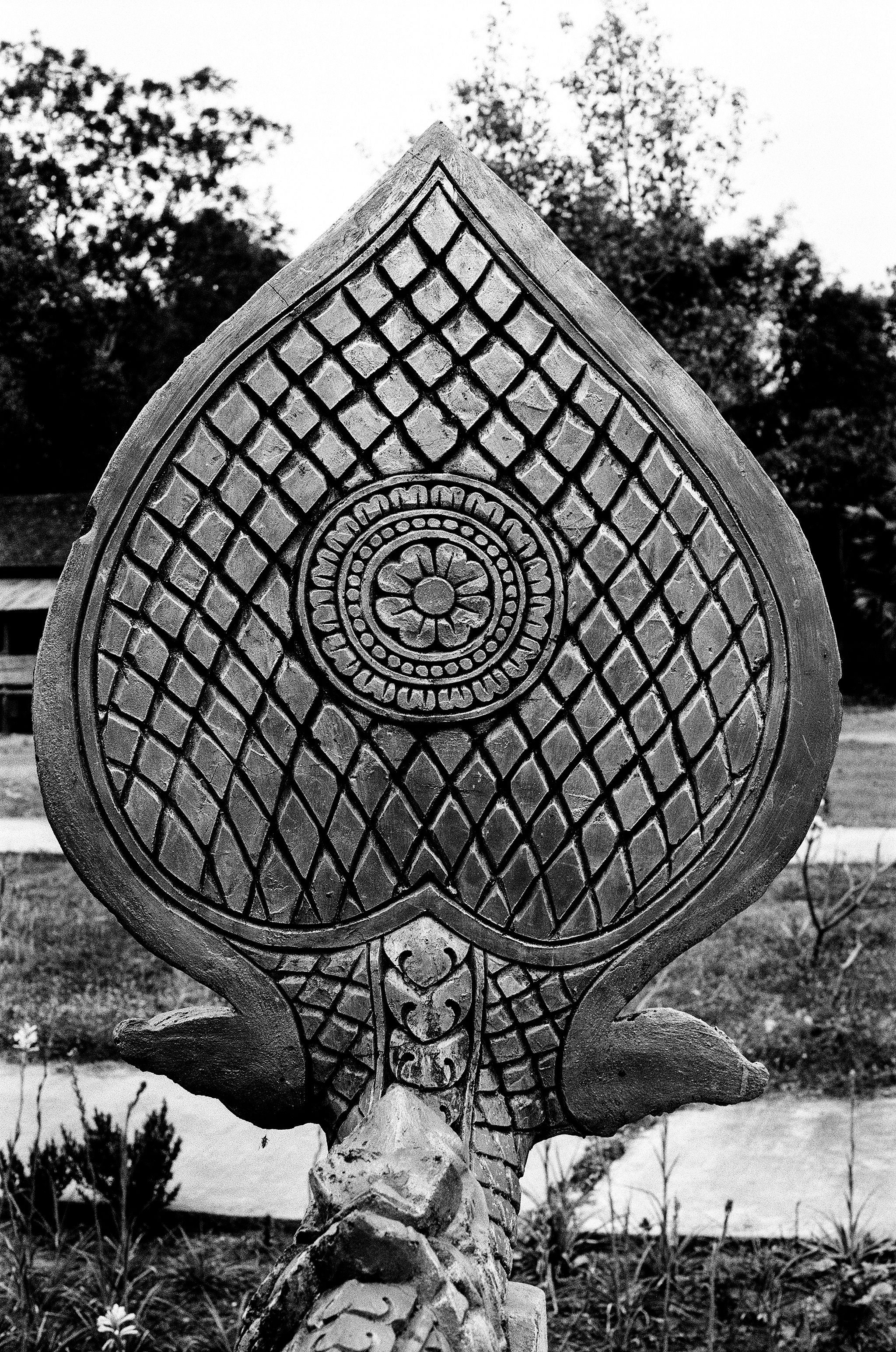 Ornate stone sculptural relief with teardrop shape and intricate carved patterns