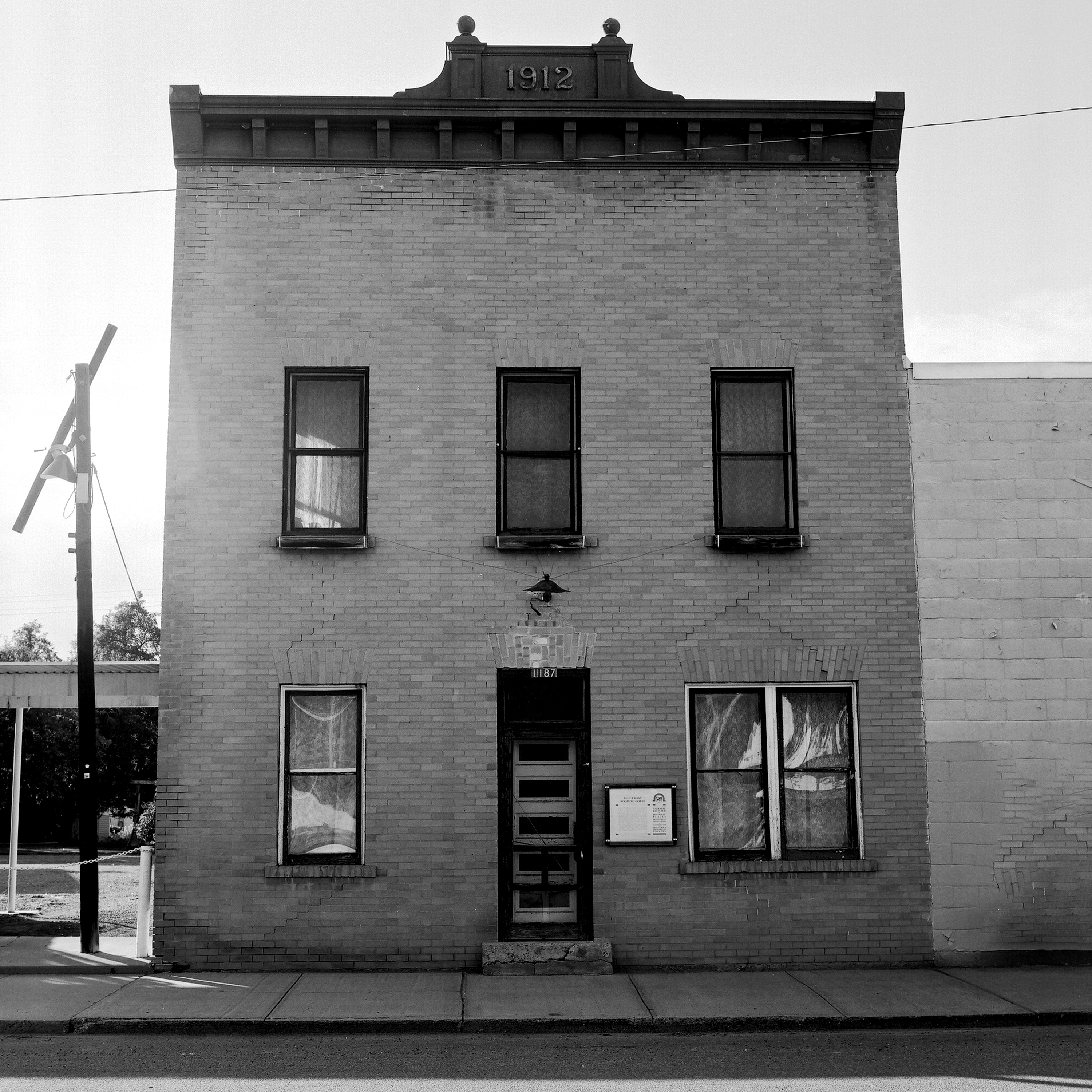 Historic 1912 two-story brick building with ornate cornice and tall windows on main street