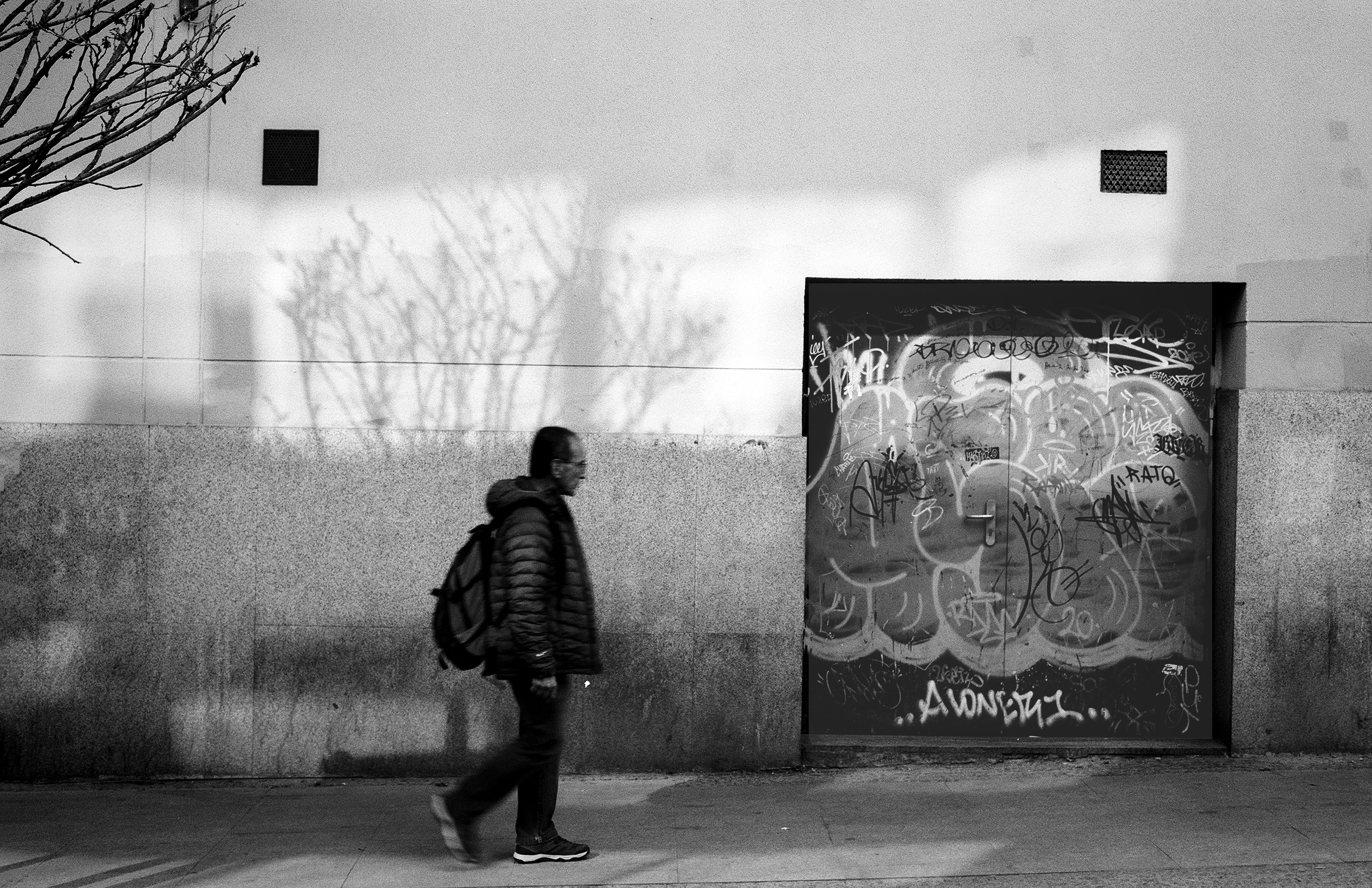 Urban street scene with pedestrian and graffiti door