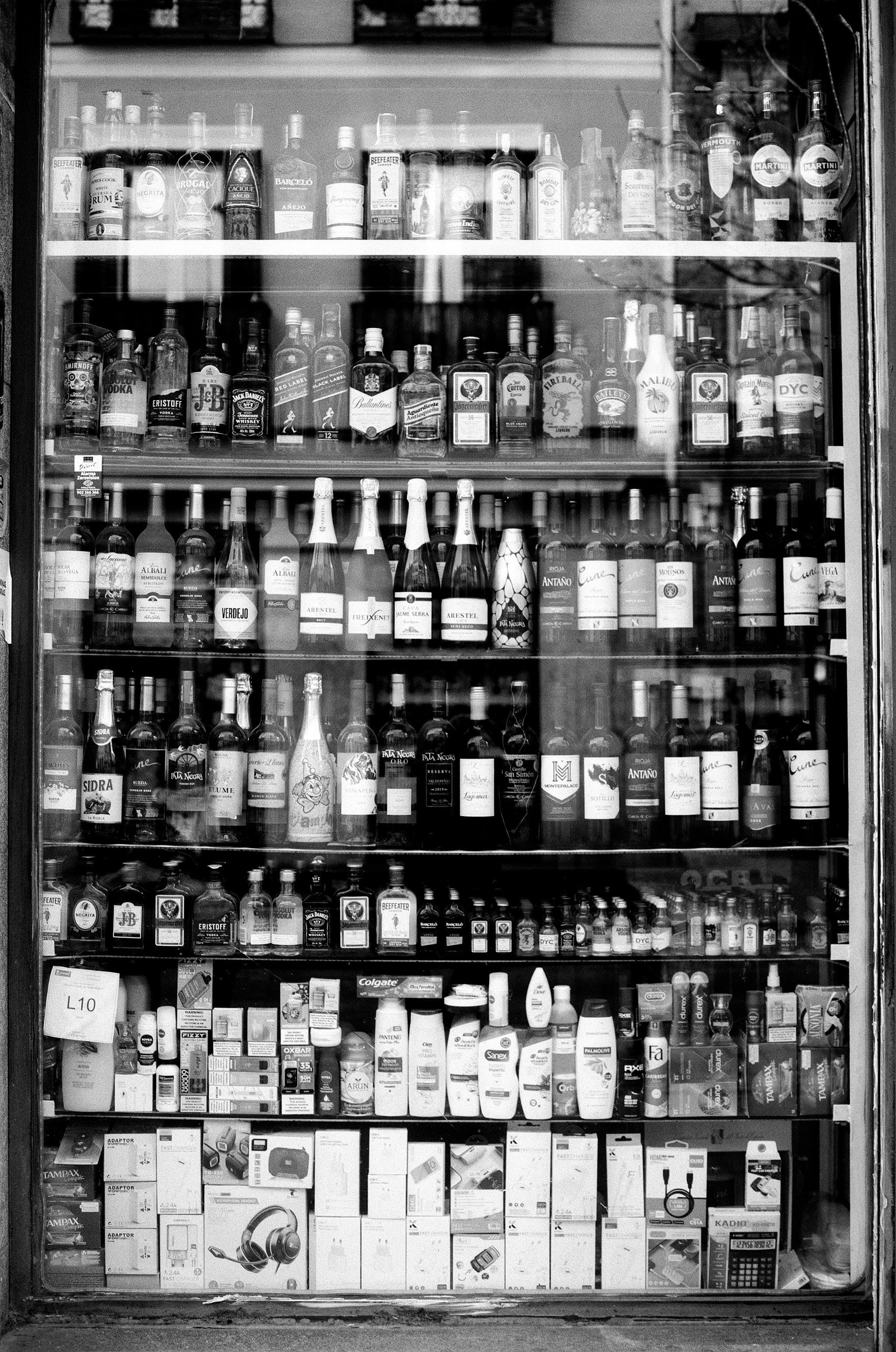 Shop window display with multiple shelves of bottles - liquor and wine store retail
