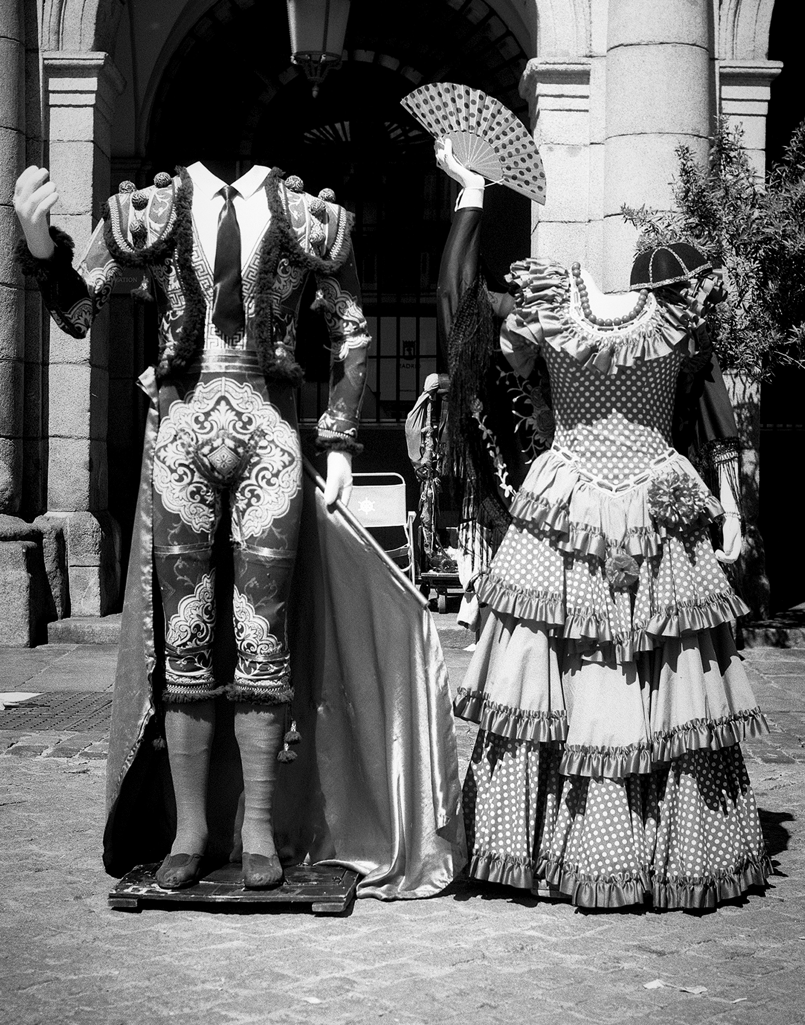 Street performers in elaborate colorful embroidered costumes and traditional dress under archway