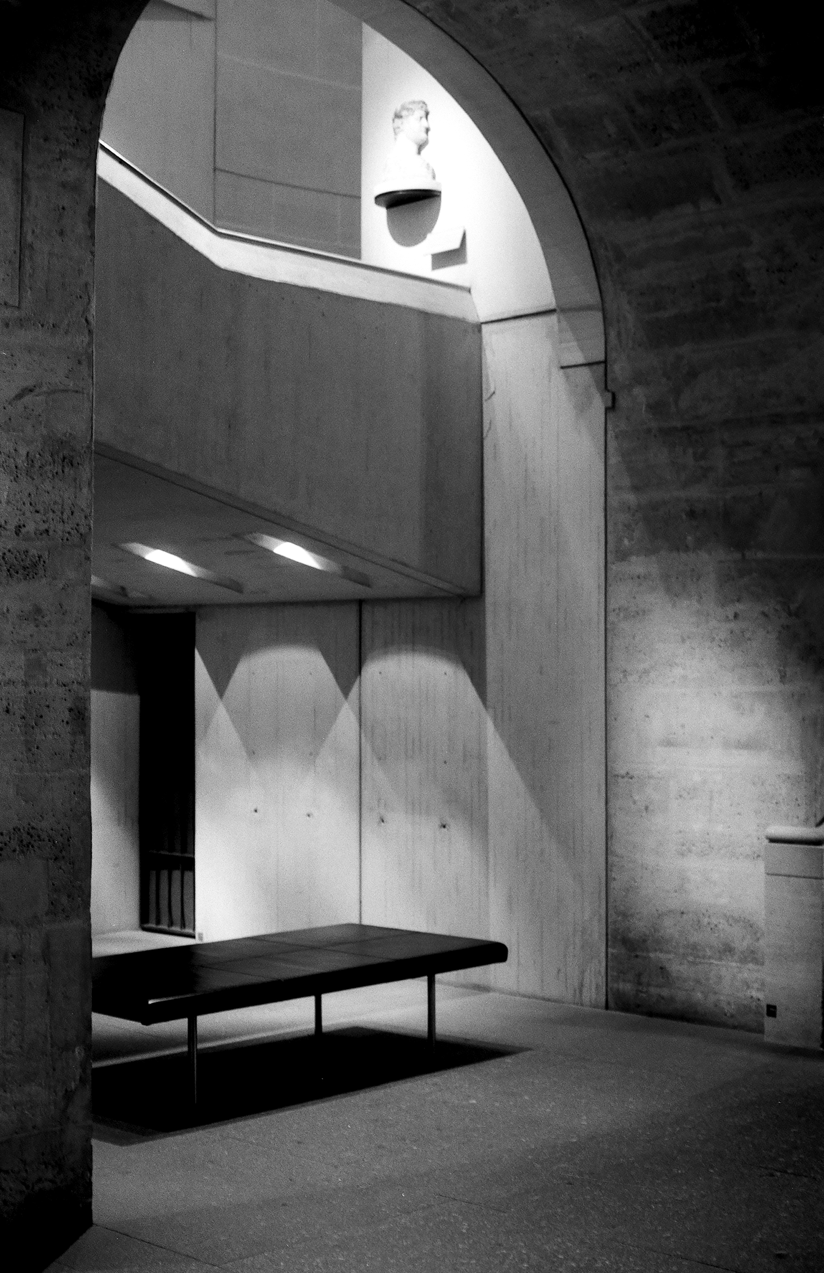 Ville de Paris information kiosk on rain-slicked cobblestone street with Haussmann buildings receding