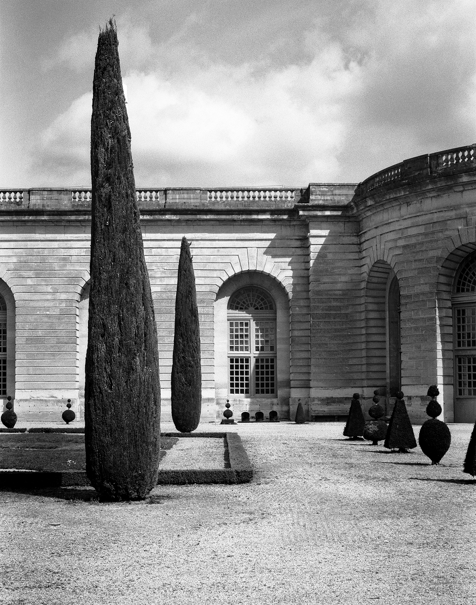 Versailles formal garden with tall cypress trees and pyramid topiary arrangement