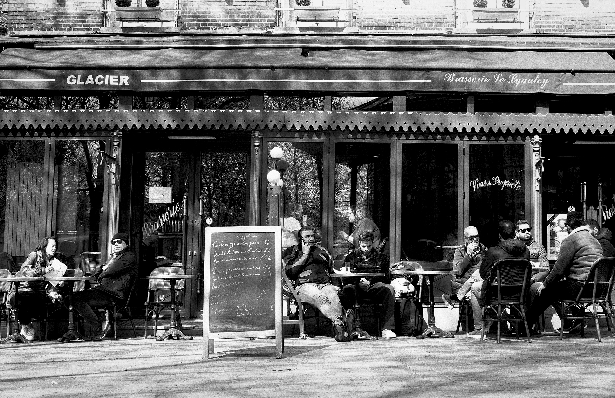 Glacier Brasserie le Lyanley cafe with diners seated at outdoor tables along Paris street