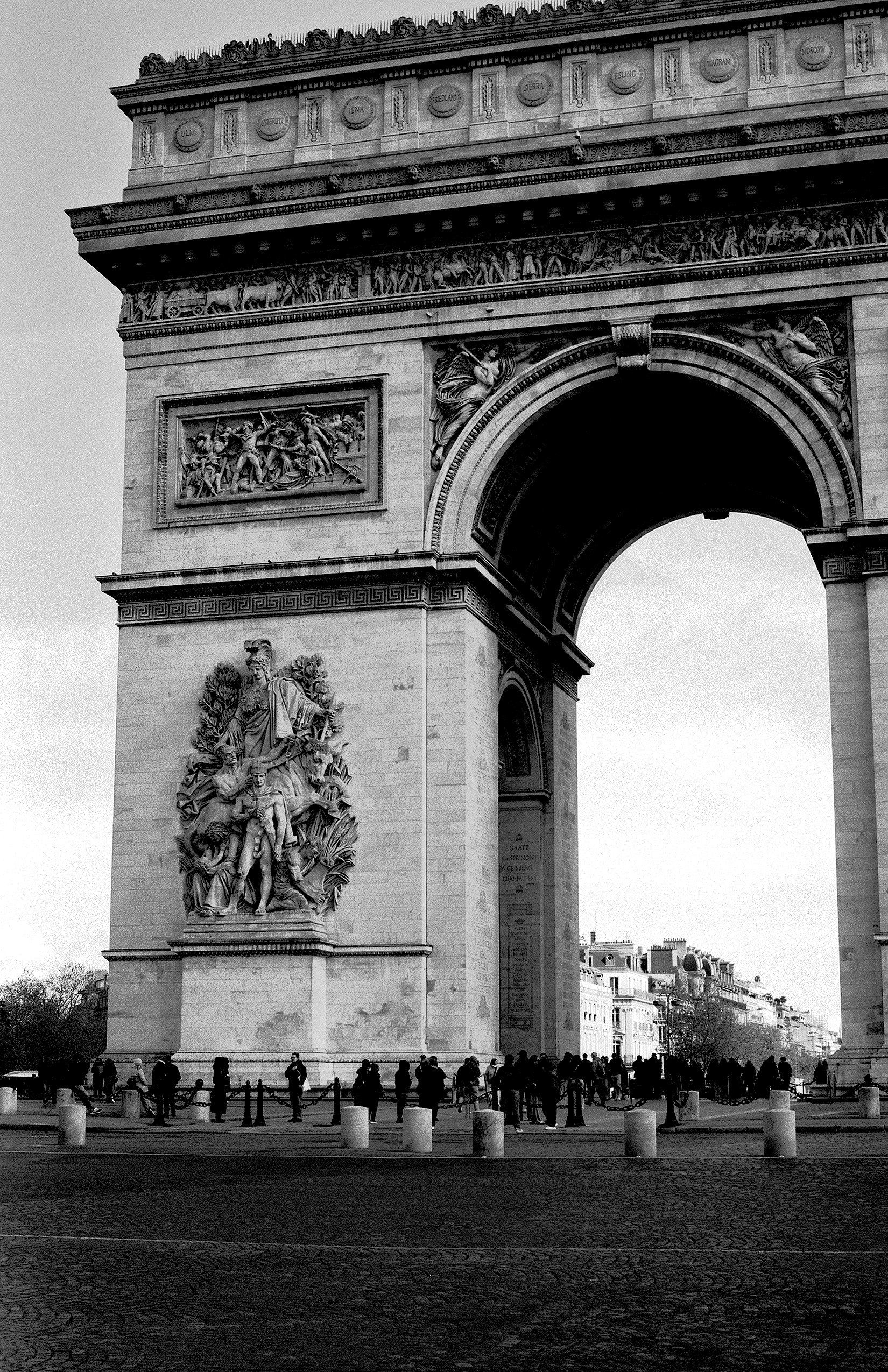 Arc de Triomphe monumental arch with sculptural reliefs and people gathered below