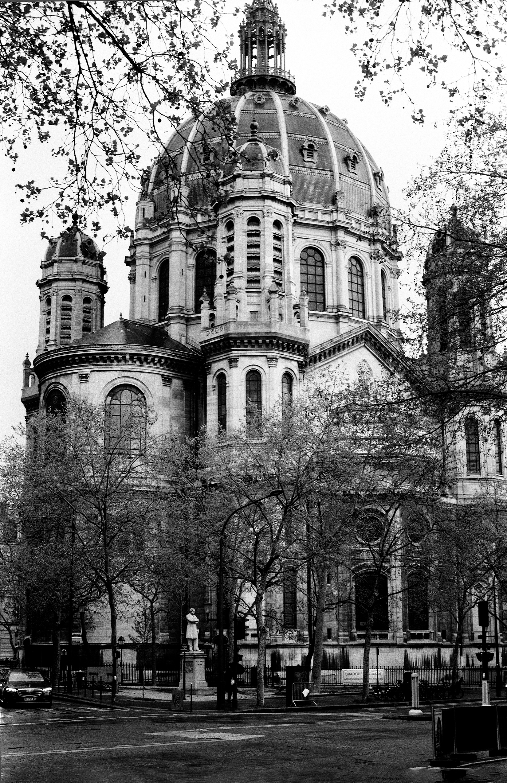 Alexander Nevsky Cathedral dome surrounded by bare tree branches against grey sky