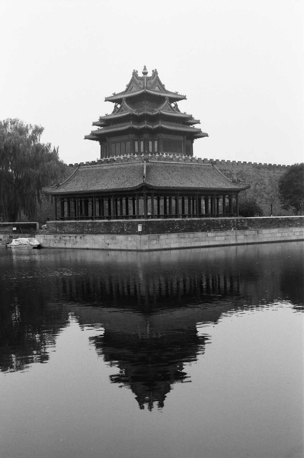 Forbidden City corner tower with traditional architecture reflected in moat water