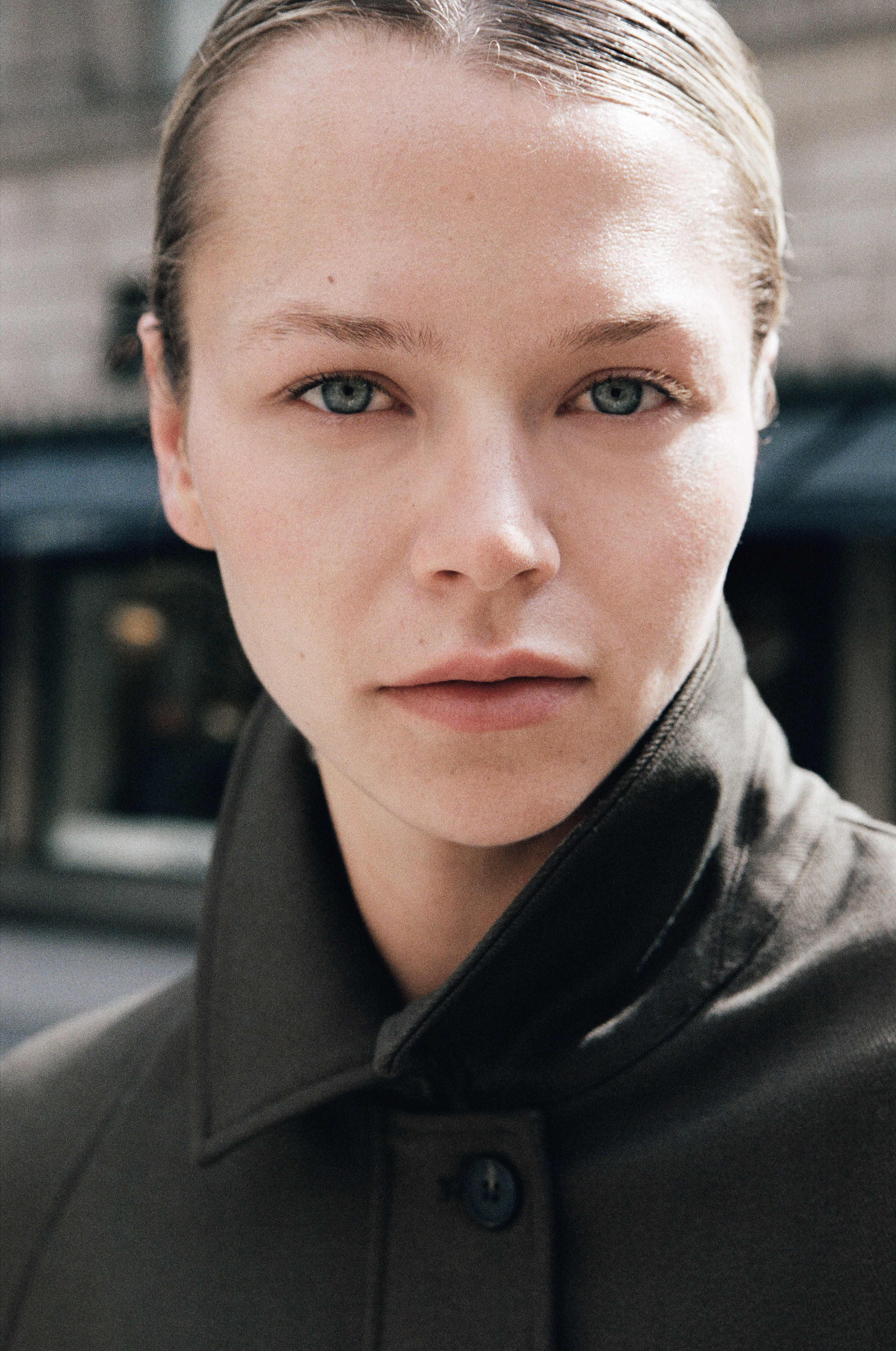 Color close-up portrait of blue-eyed blonde model with popped leather collar