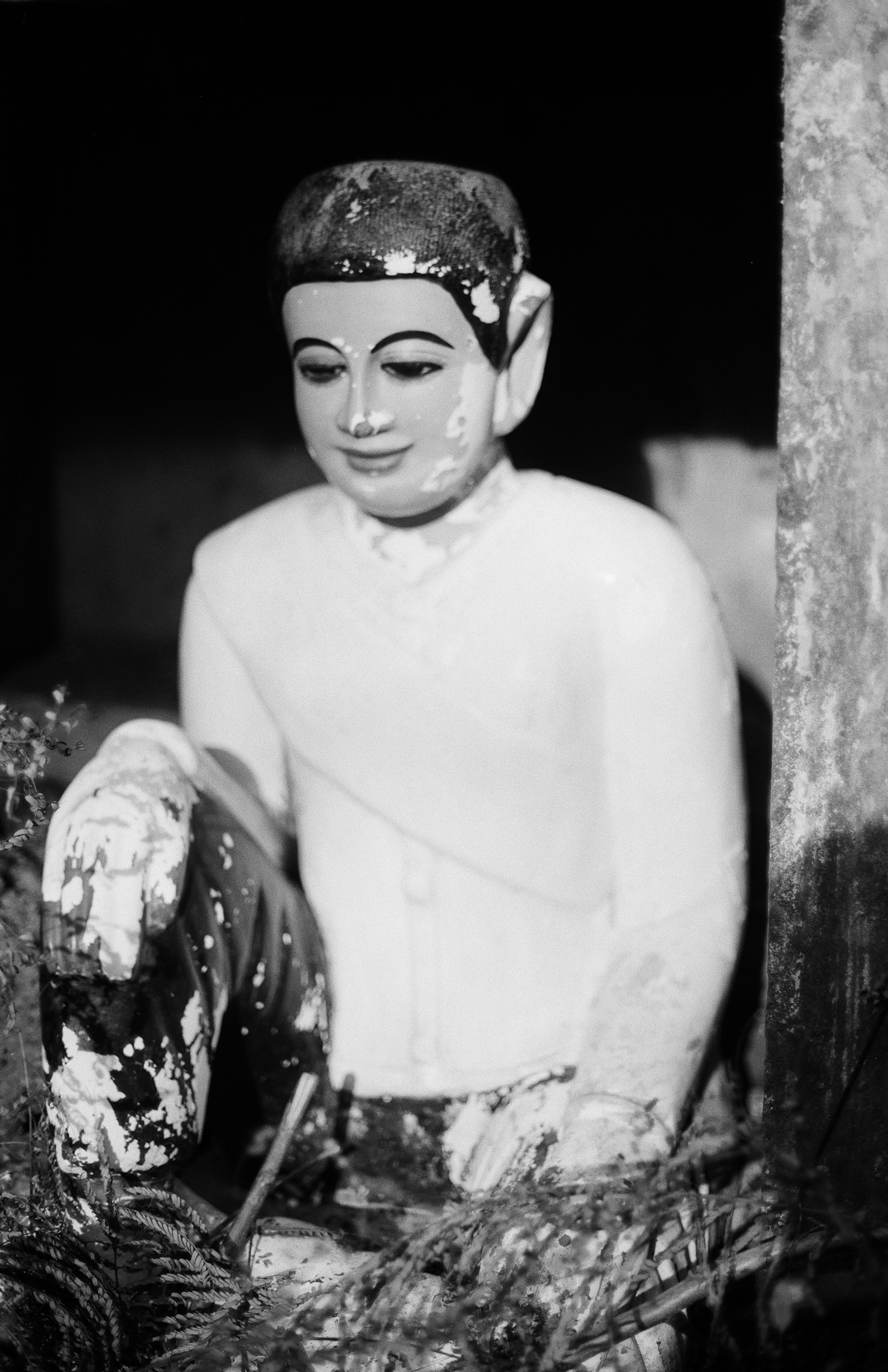 Buddha statue in meditation pose wearing ornate headdress with contemplative expression