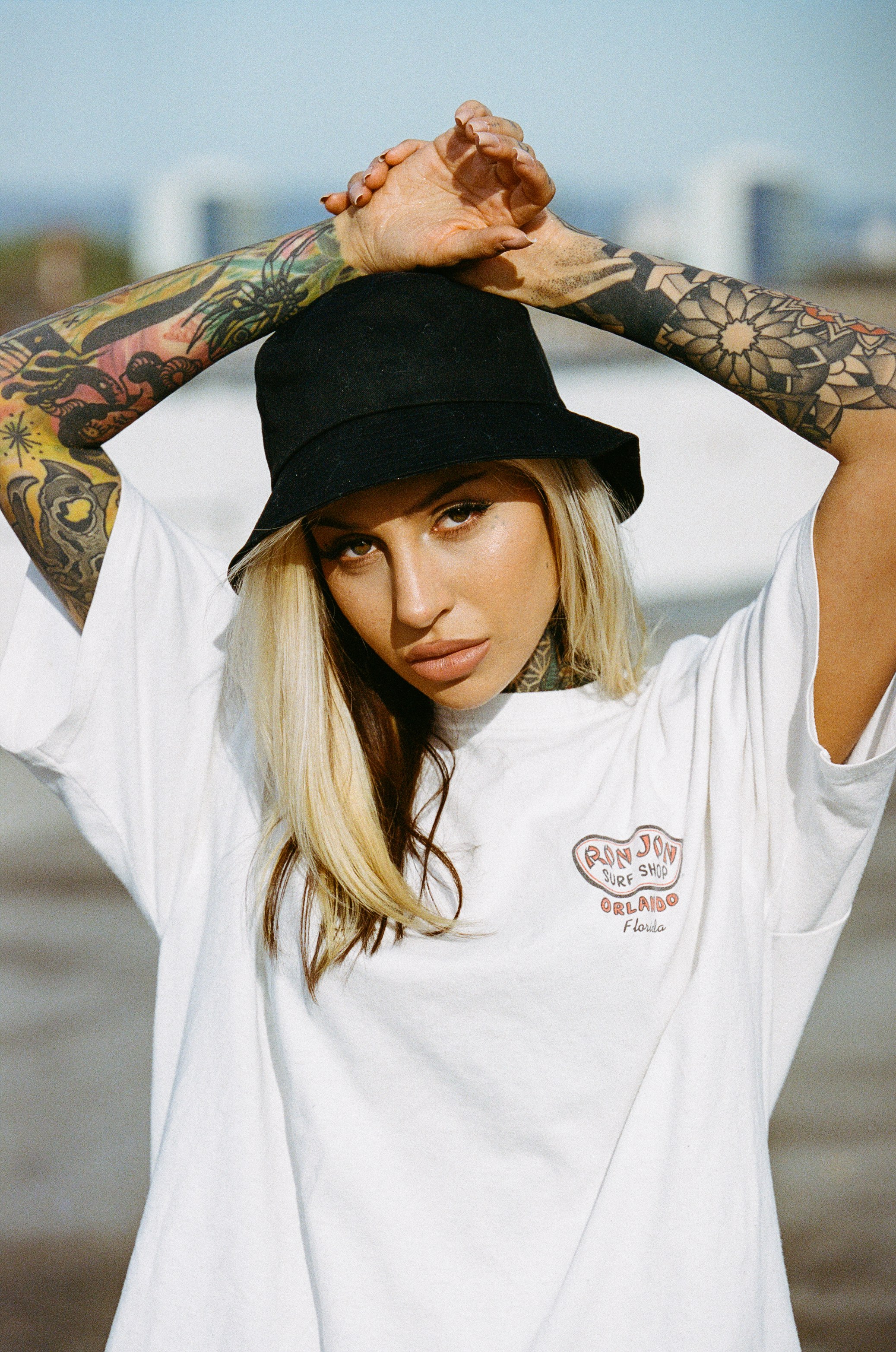 Tattooed blonde model in bucket hat and Ron Jon surf tee coastal film