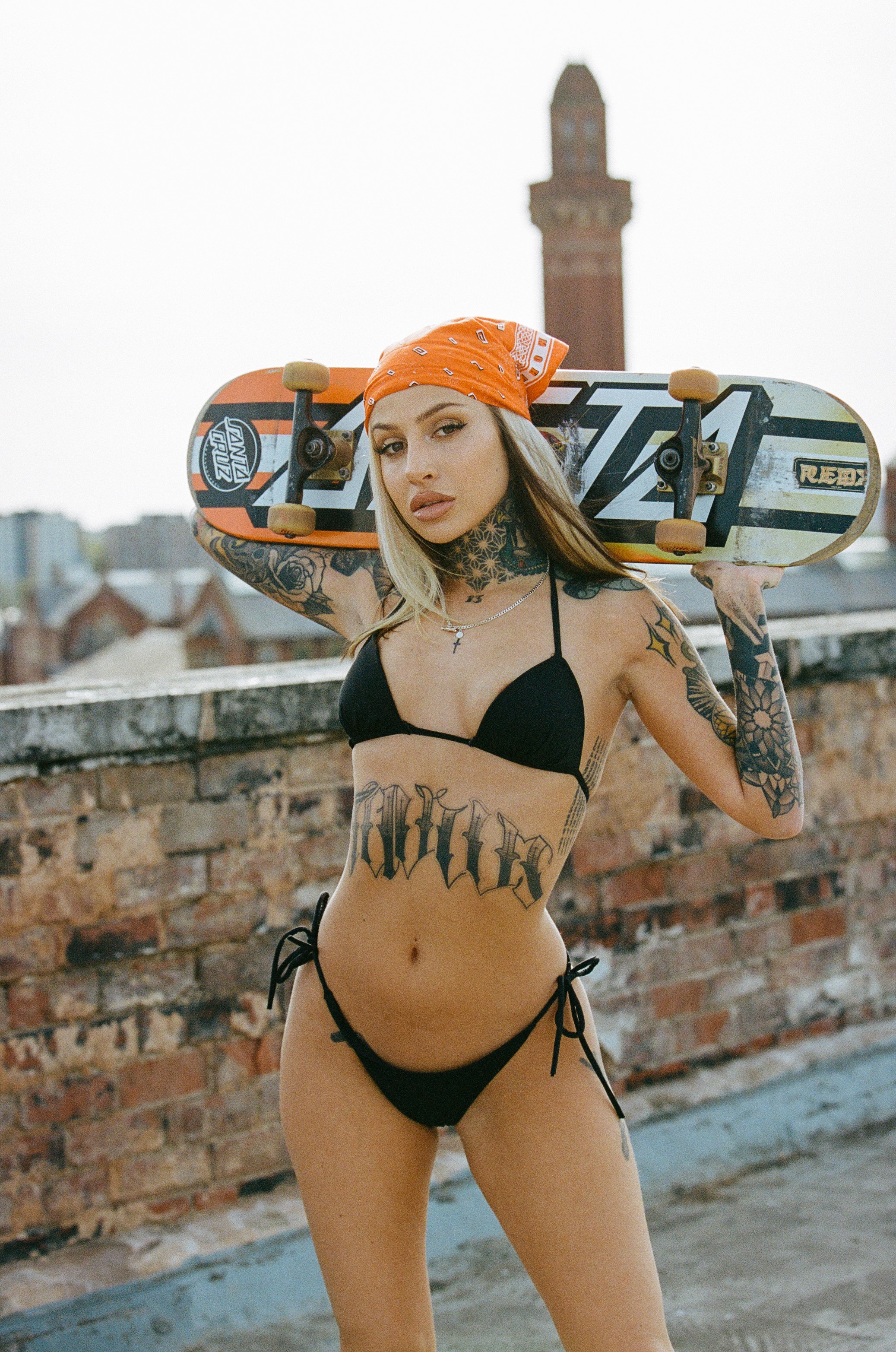 Model on rooftop with skateboard orange bandana urban skyline film
