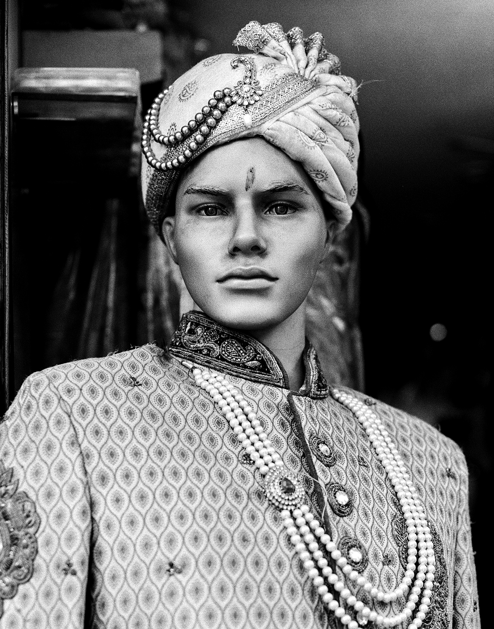 Black and white portrait man in traditional royal ceremonial dress with ornamental turban and jeweled necklace