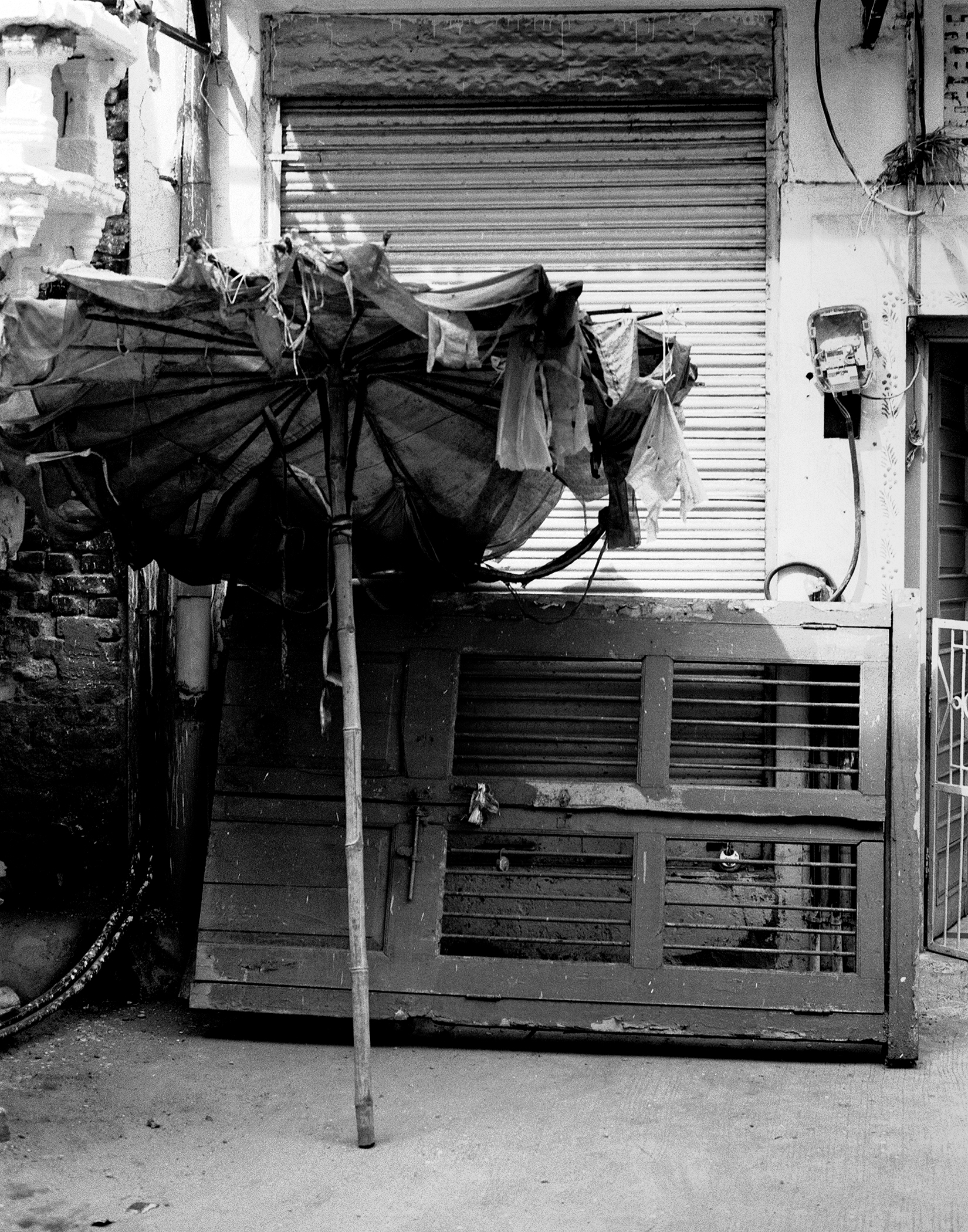 Black and white motorcycle repair shop storefront with metal shutter laundry hanging above