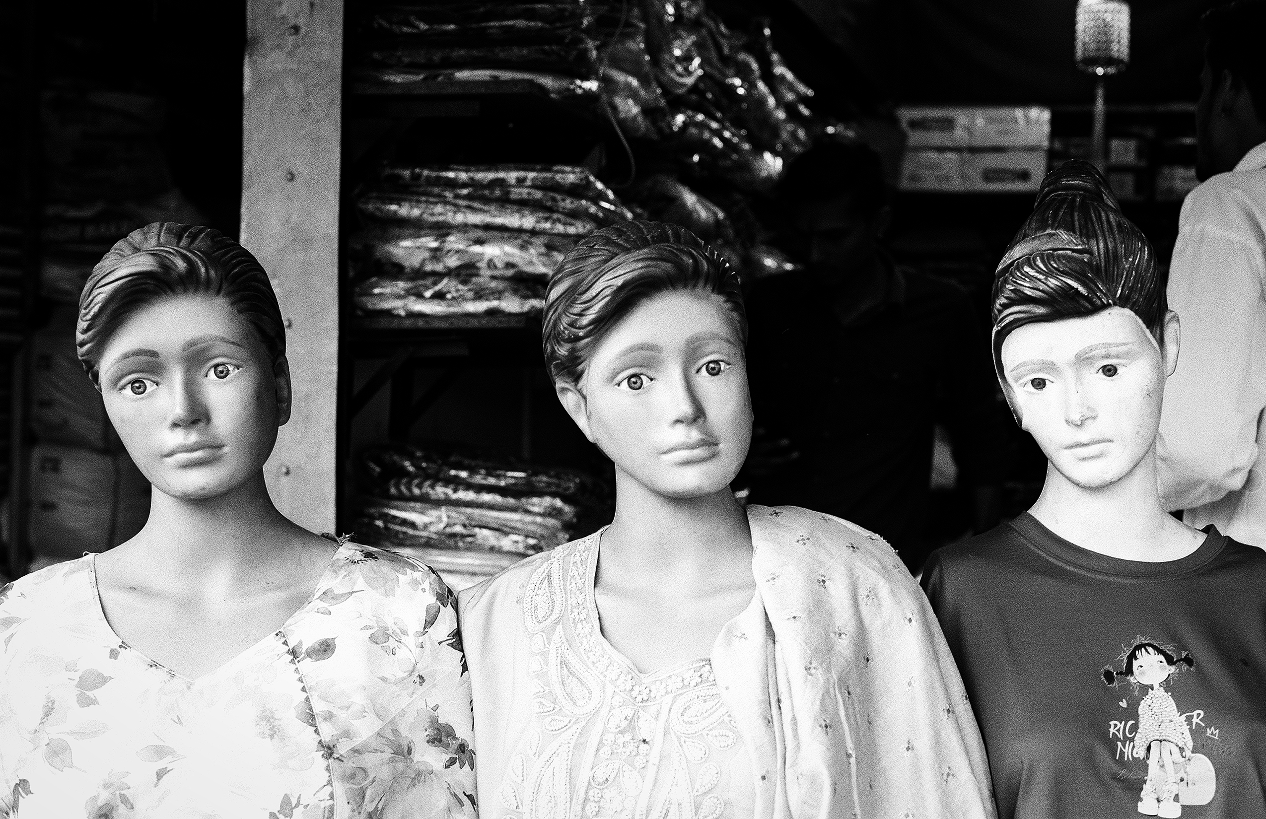 Black and white three mannequin heads displaying traditional Indian dress with elaborate jewelry turbans