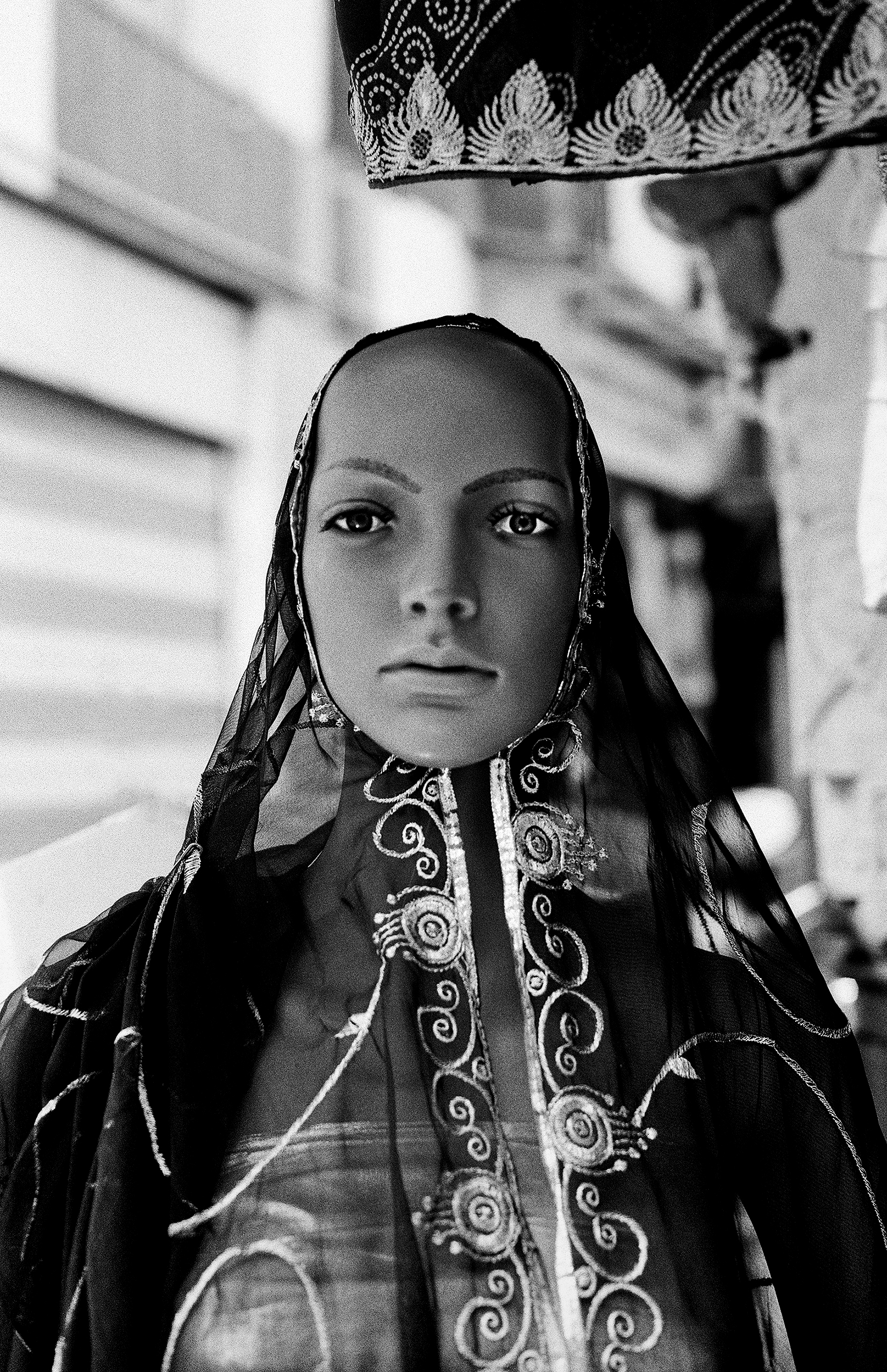 Black and white portrait woman in traditional embroidered dress with ornamental headscarf