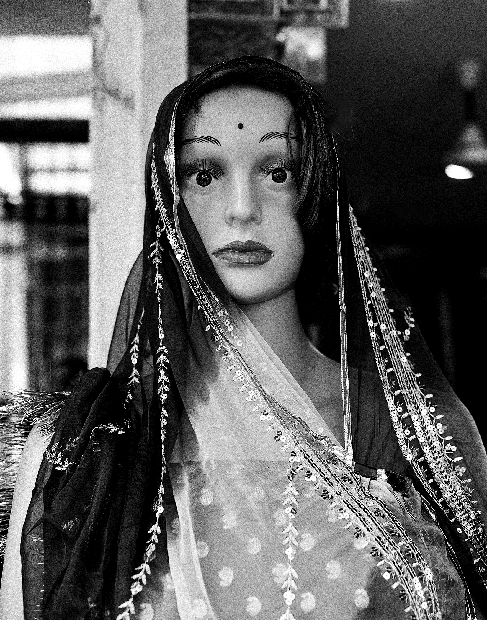 Black and white portrait woman in elaborate traditional dress with ornamental veil and jewelry