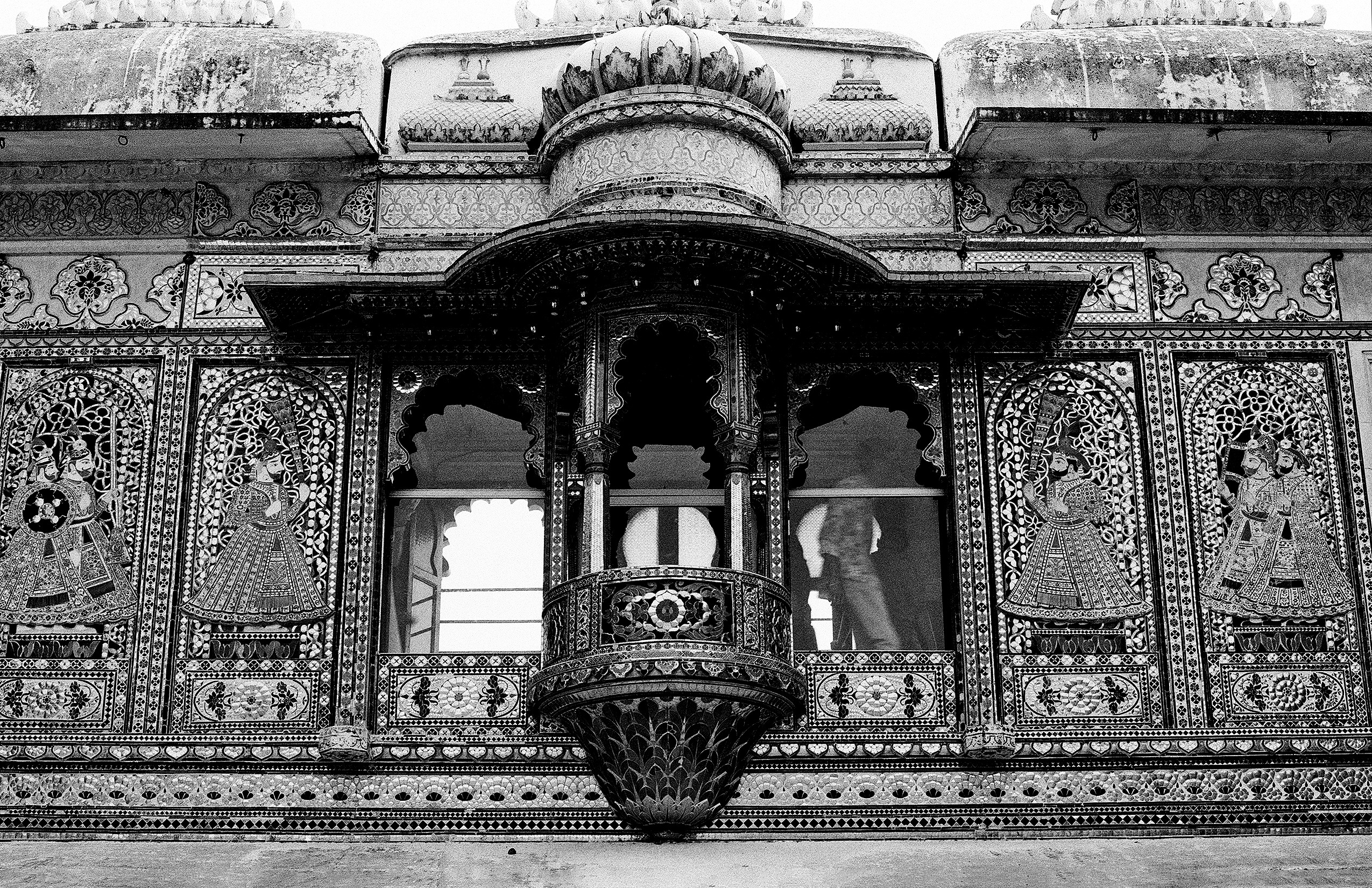 Black and white palace balcony with elaborate inlay work floral patterns and arched openings