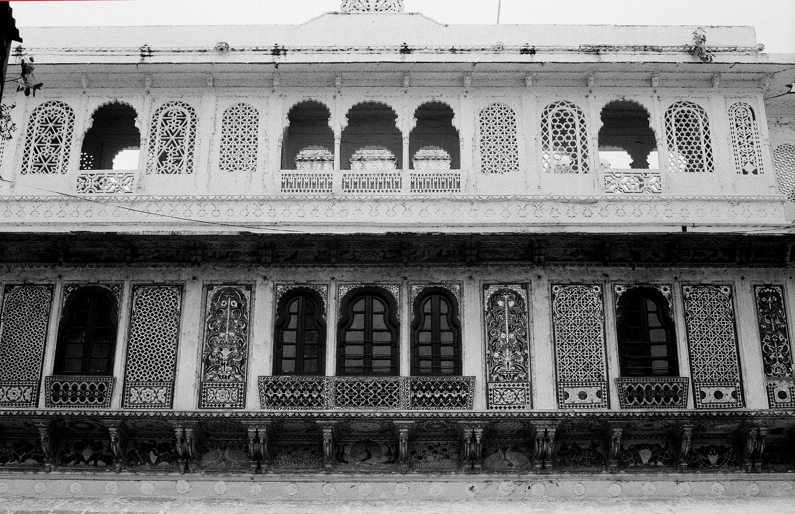 Black and white ornate palace facade with latticed screens arches and intricate carved details