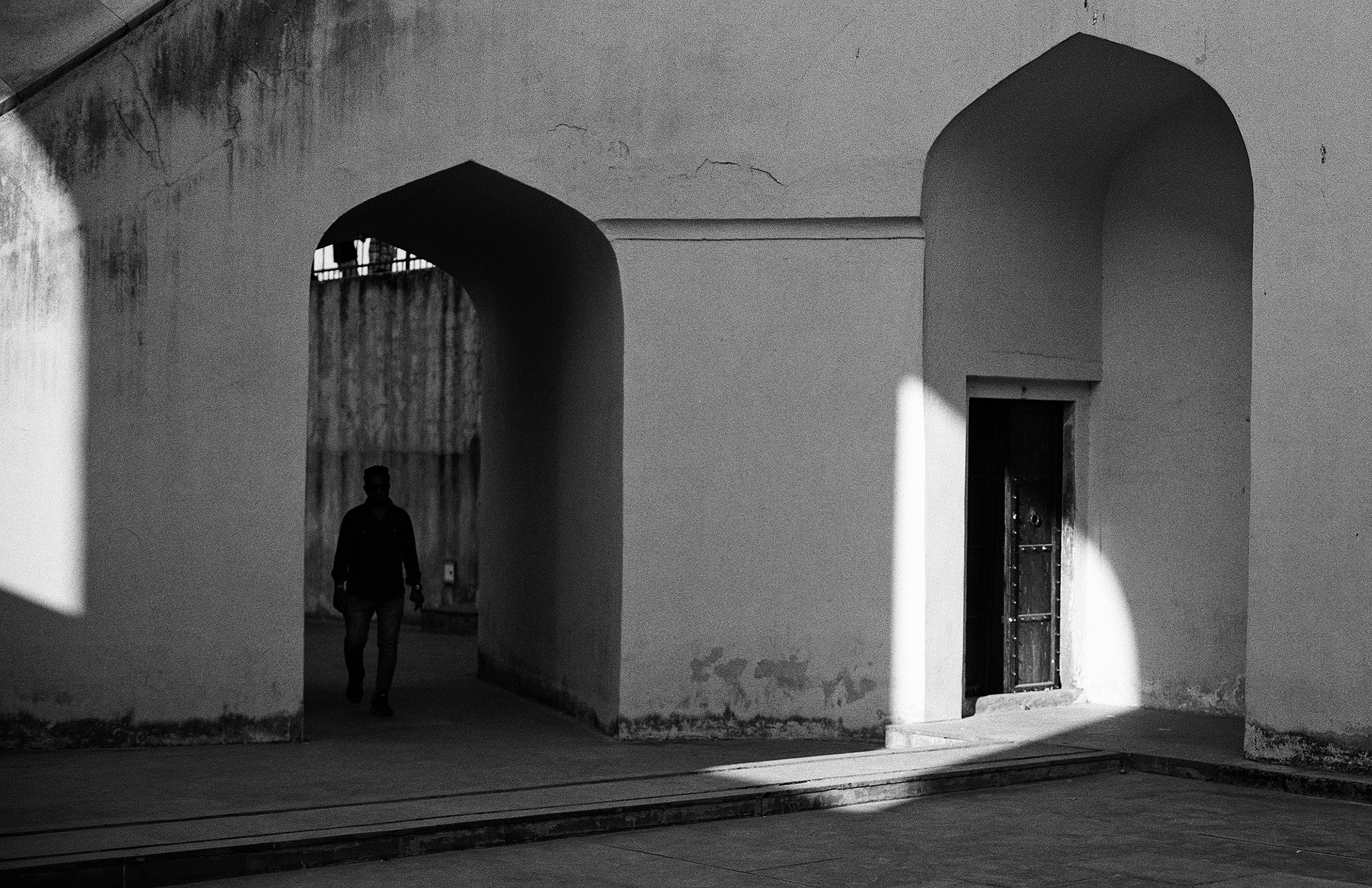 Black and white minimalist archway in white fortress structure with dramatic shadow play and geometry