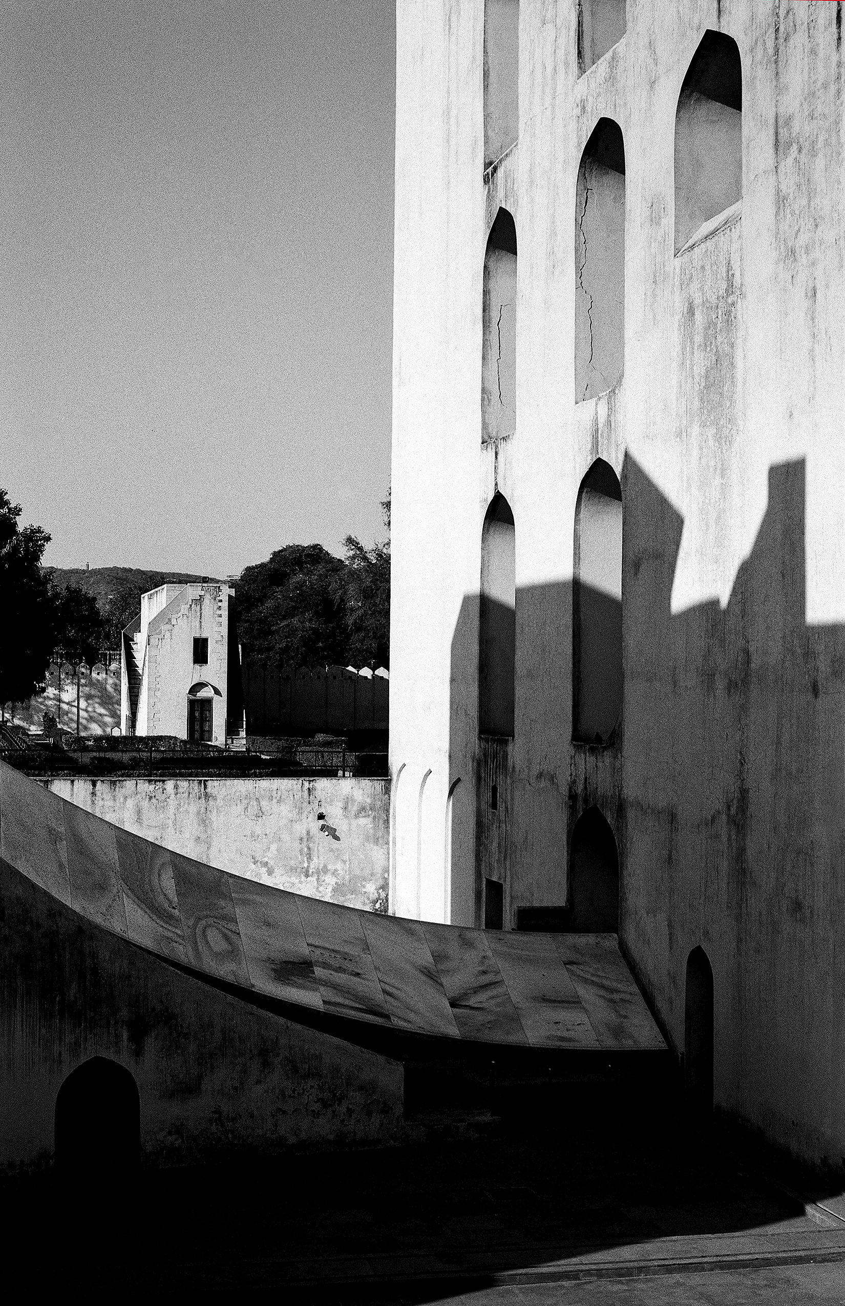 Black and white fort wall architectural detail with arched windows and dramatic shadow play
