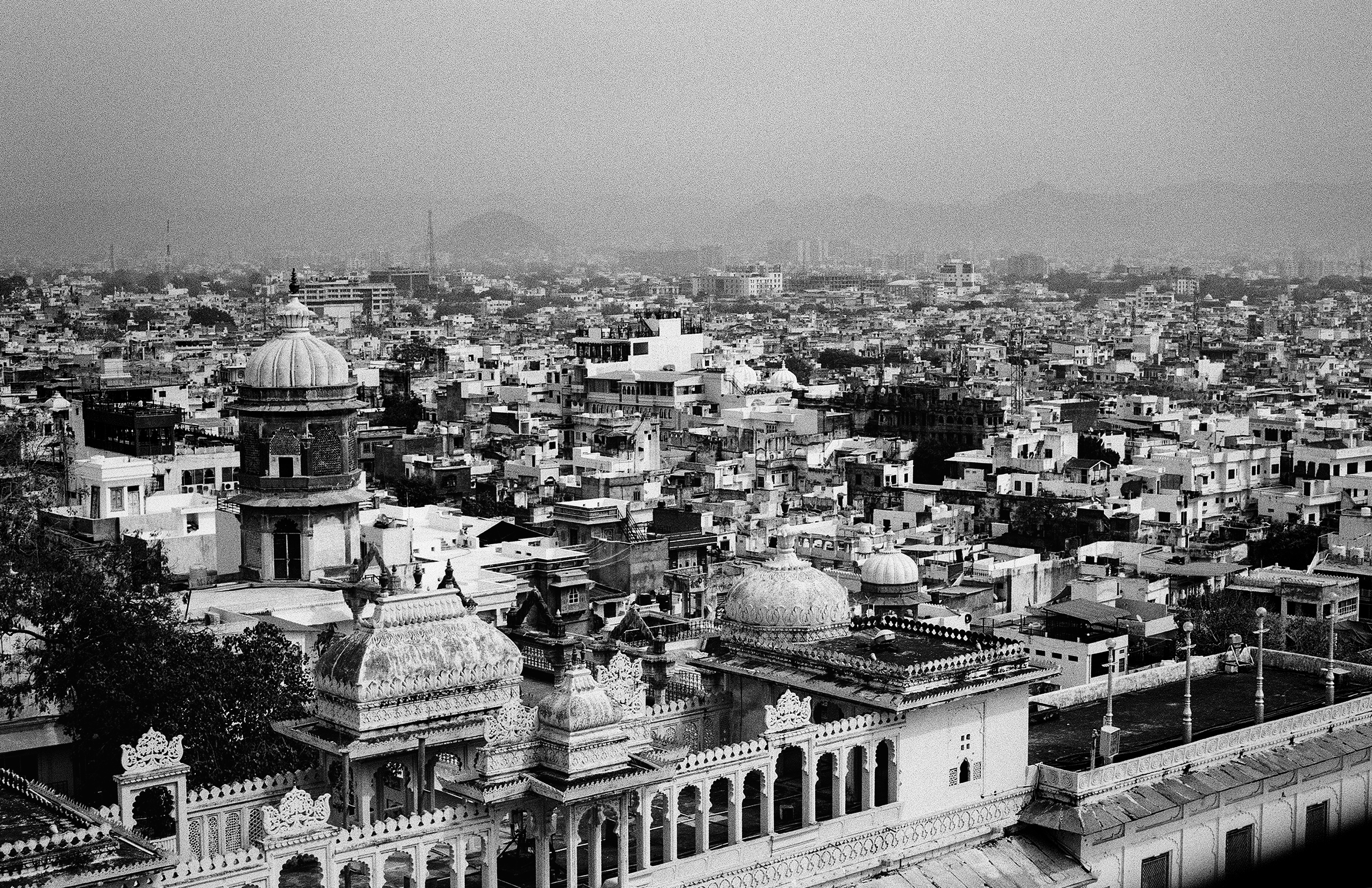 Black and white aerial city panorama showing densely packed buildings with ornate domes and palace architecture
