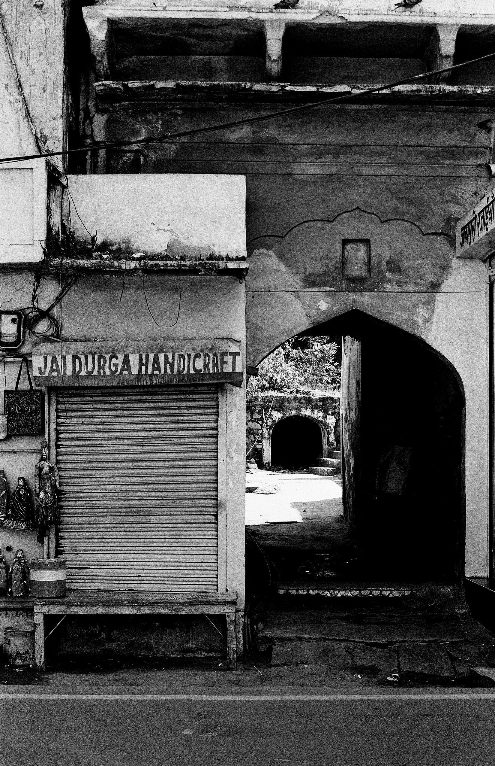 Black and white shopfront with ornate arch entrance traditional Jaipur handicraft store sign visible