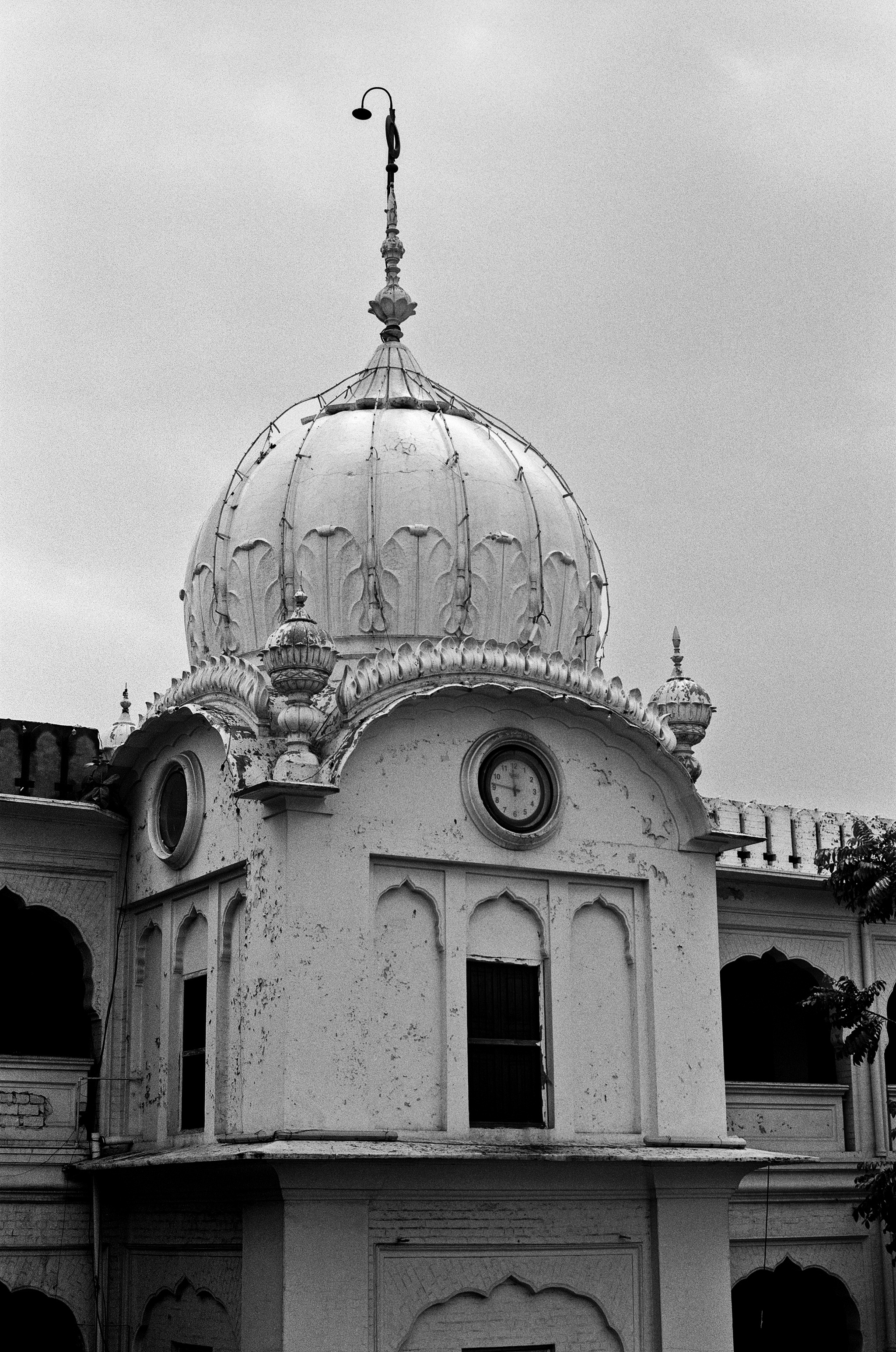 Black and white religious dome with ornamental finial clock face and decorative finials