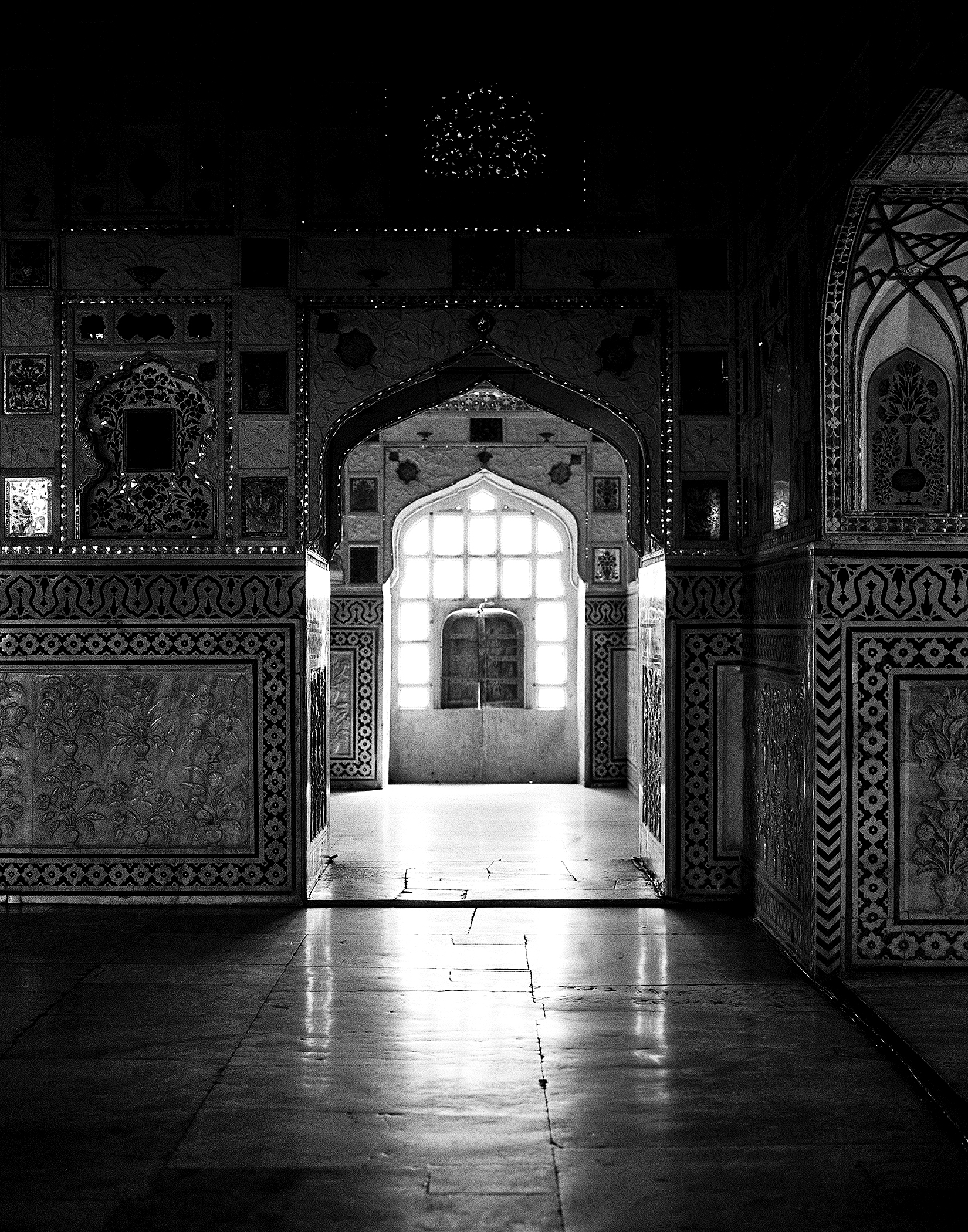 Black and white ornate temple interior with decorated walls arched doorways and bright window light