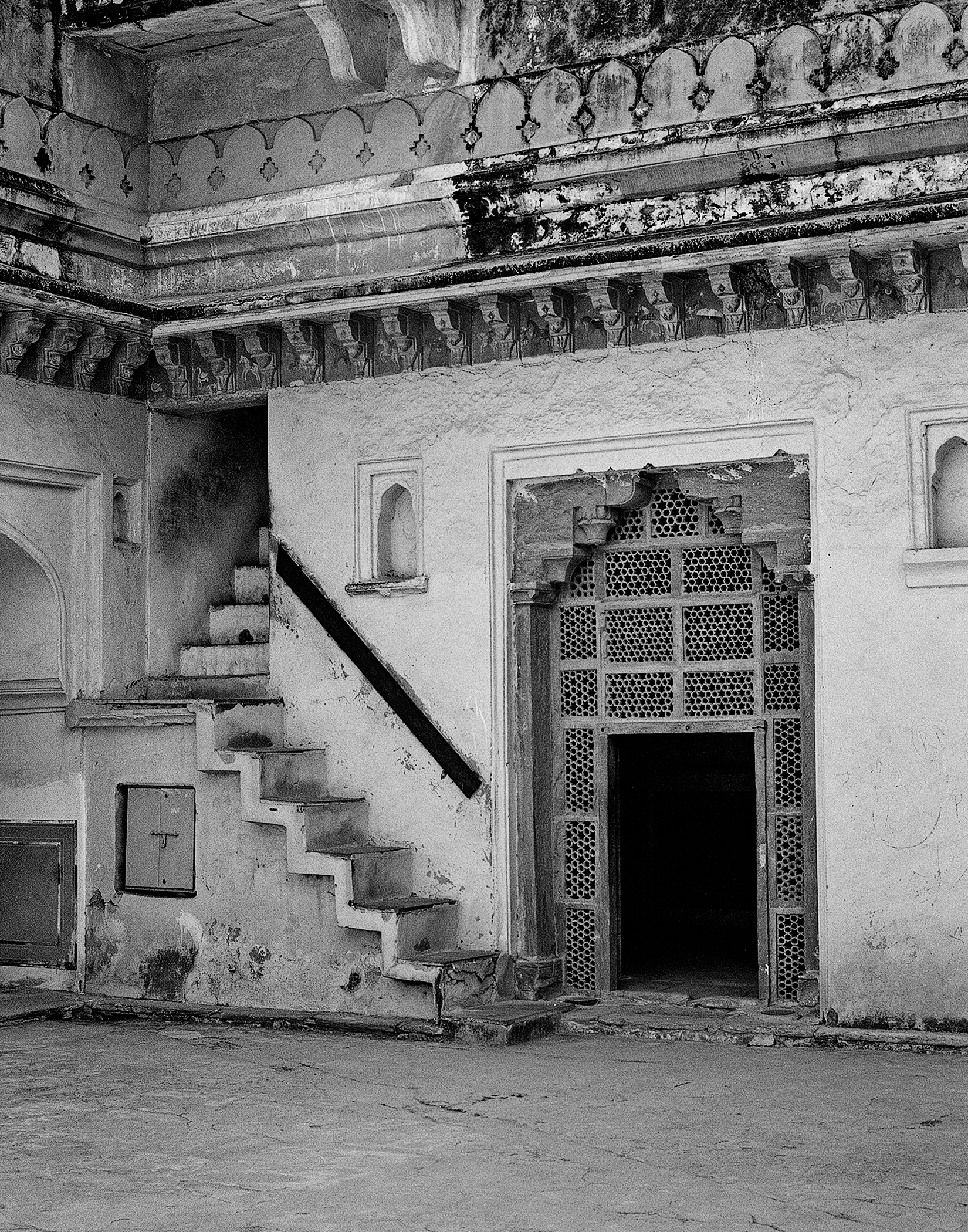 Black and white palace interior with ornate decorated ceiling curved staircase and latticed doorway