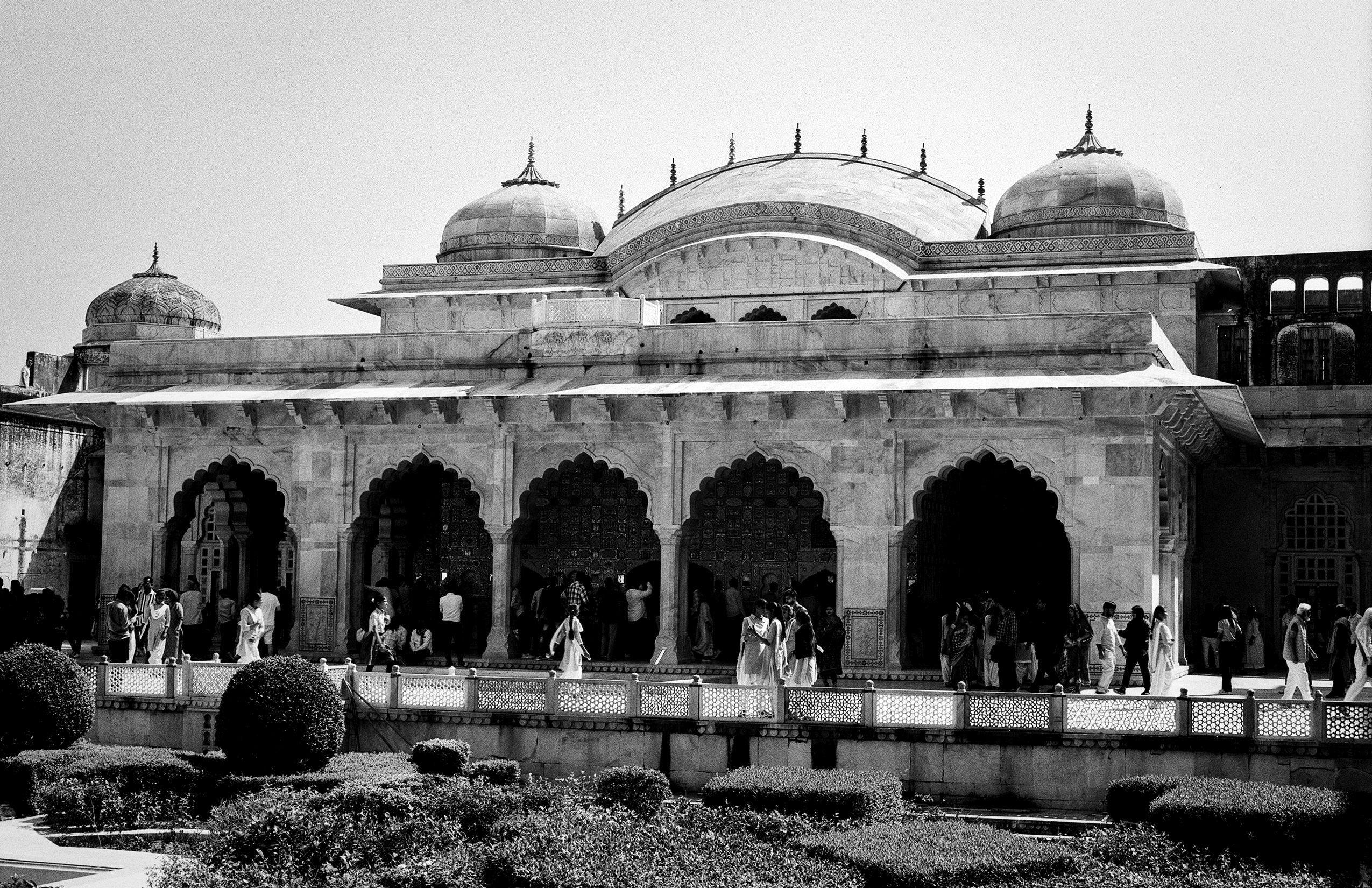 Black and white grand palace facade with five arches three domes and ornamental railings