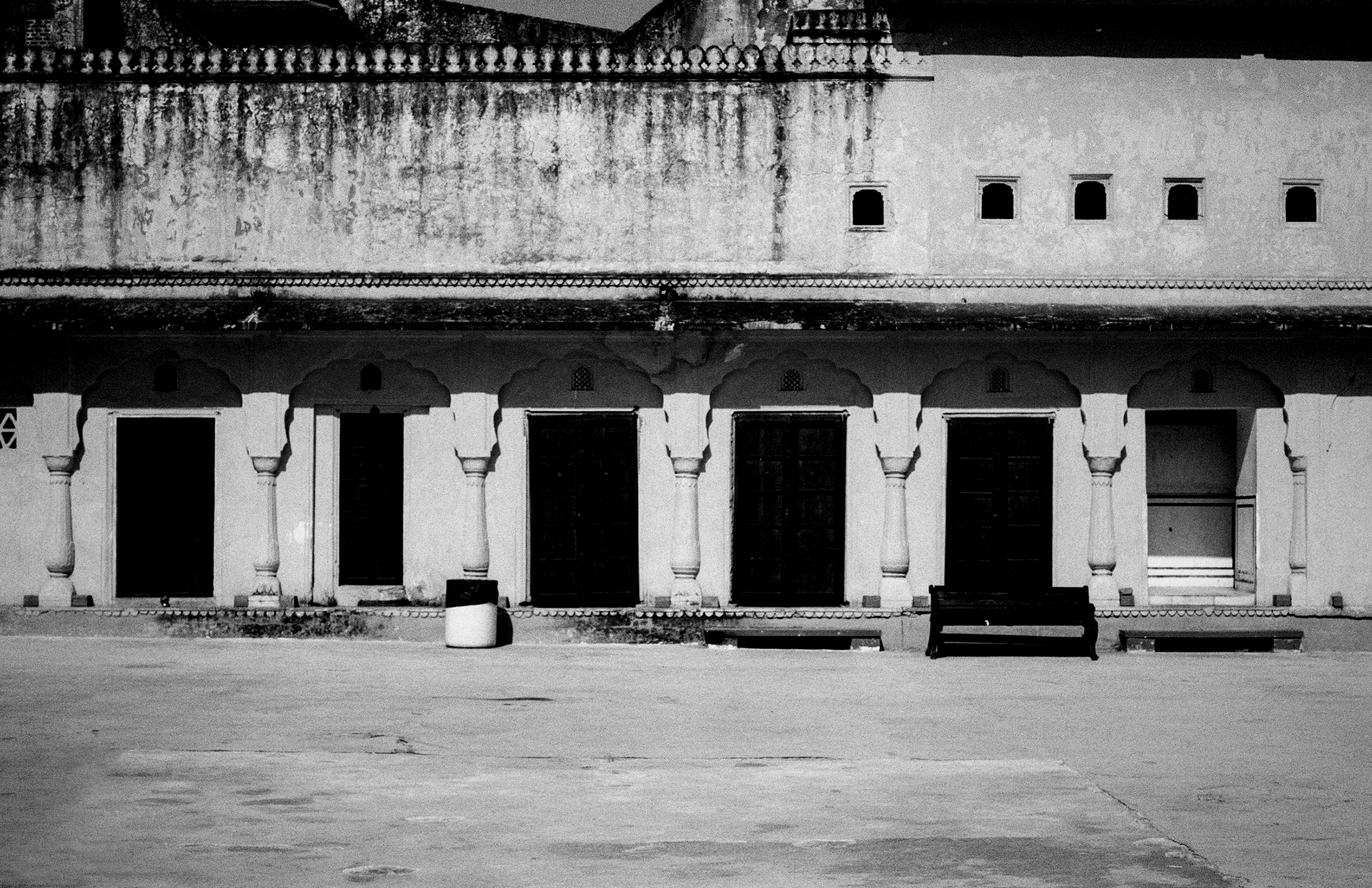 Black and white palace colonnade with six arched openings decorative railings and fortified upper level
