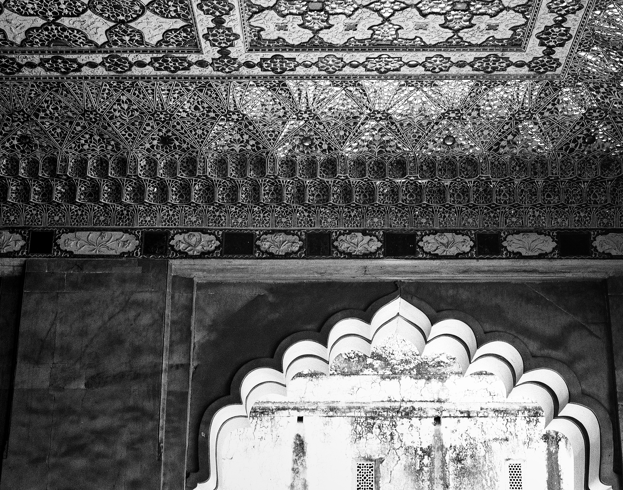 Black and white ornate ceiling detail with intricate carved lotus patterns and decorative tile work